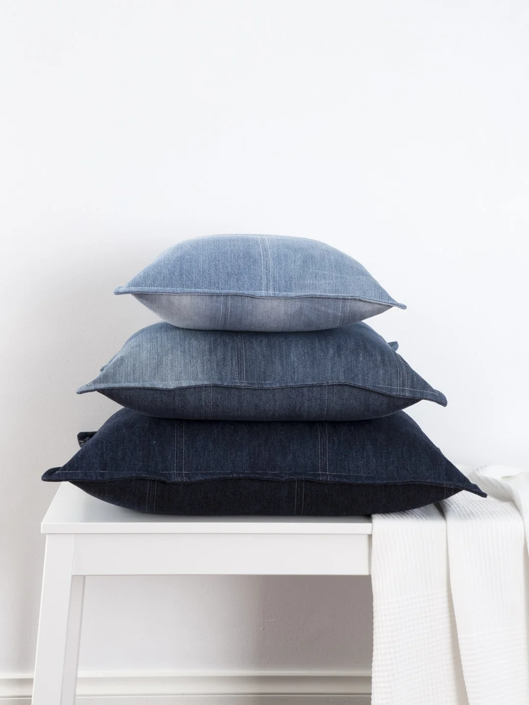 Stack of JEANBAG Minimalist cushions by KT Doyle, handmade from recycled denim