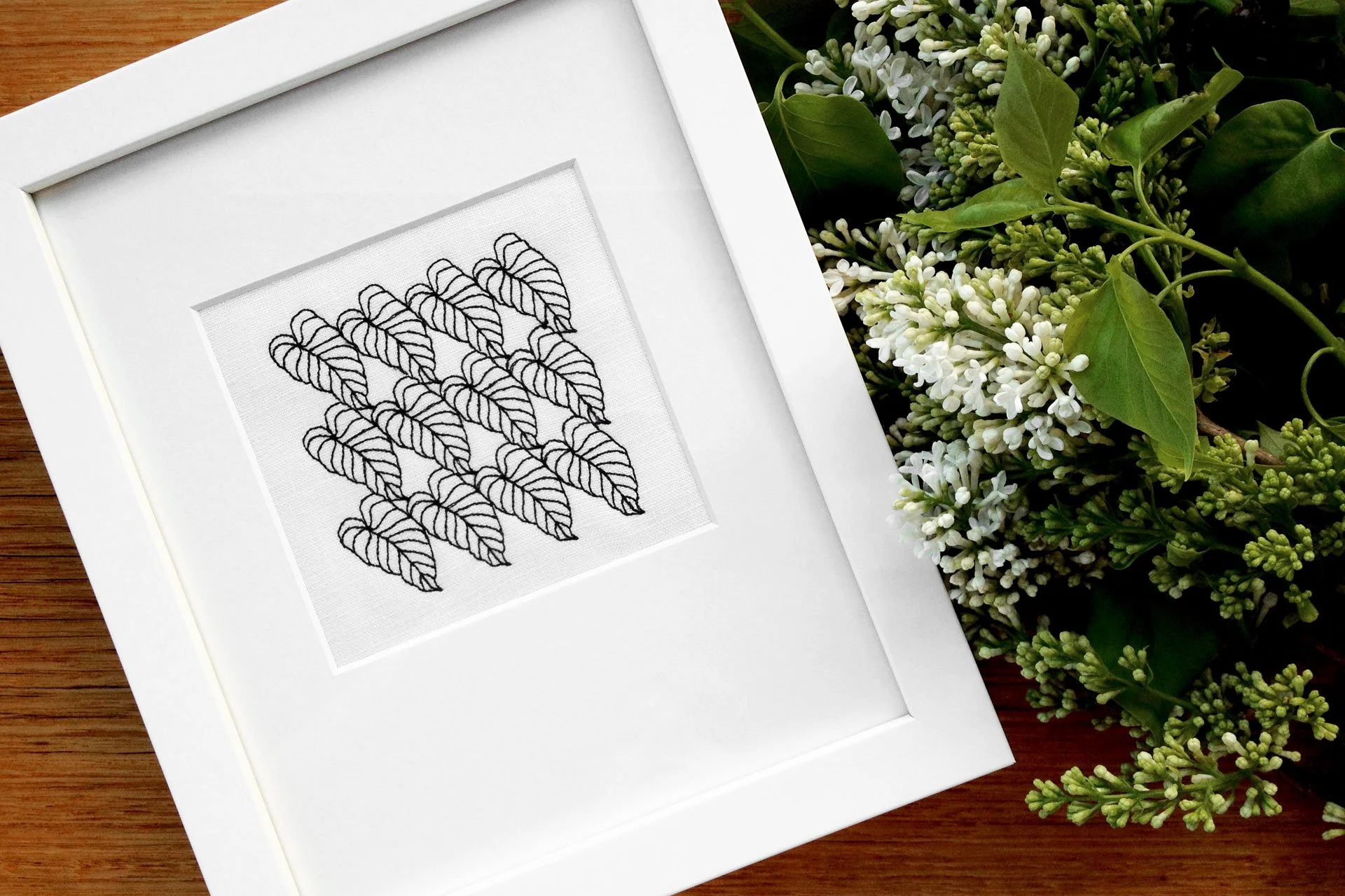 CP1 botanical embroidery from the Collected Patterns series by Australian artist KT Doyle, black thread on white linen, shown framed
