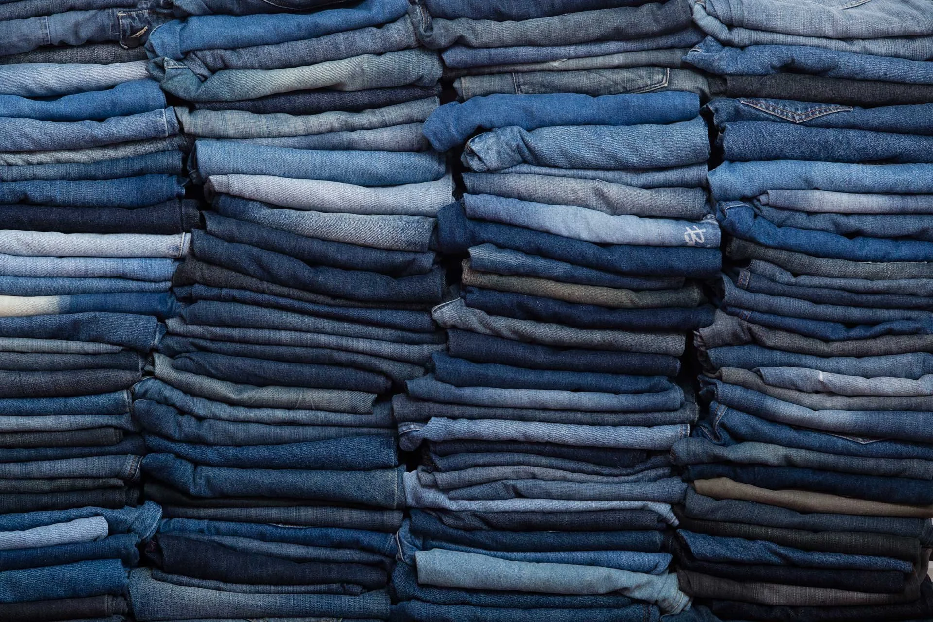 Stacks of unwanted denim jeans collected for reuse in the JEANBAG sustainability project