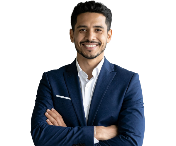 A man in a dark blue suit with a white shirt, smiling with arms crossed.
