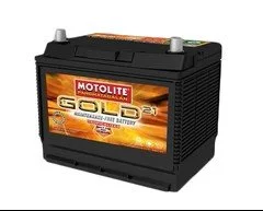 A black Motolite Gold automotive battery with a red and yellow label, featuring a fiery background.