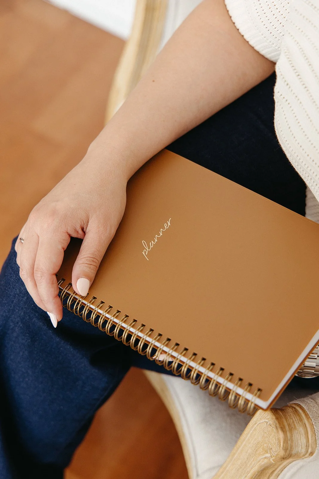 hand on brown planner