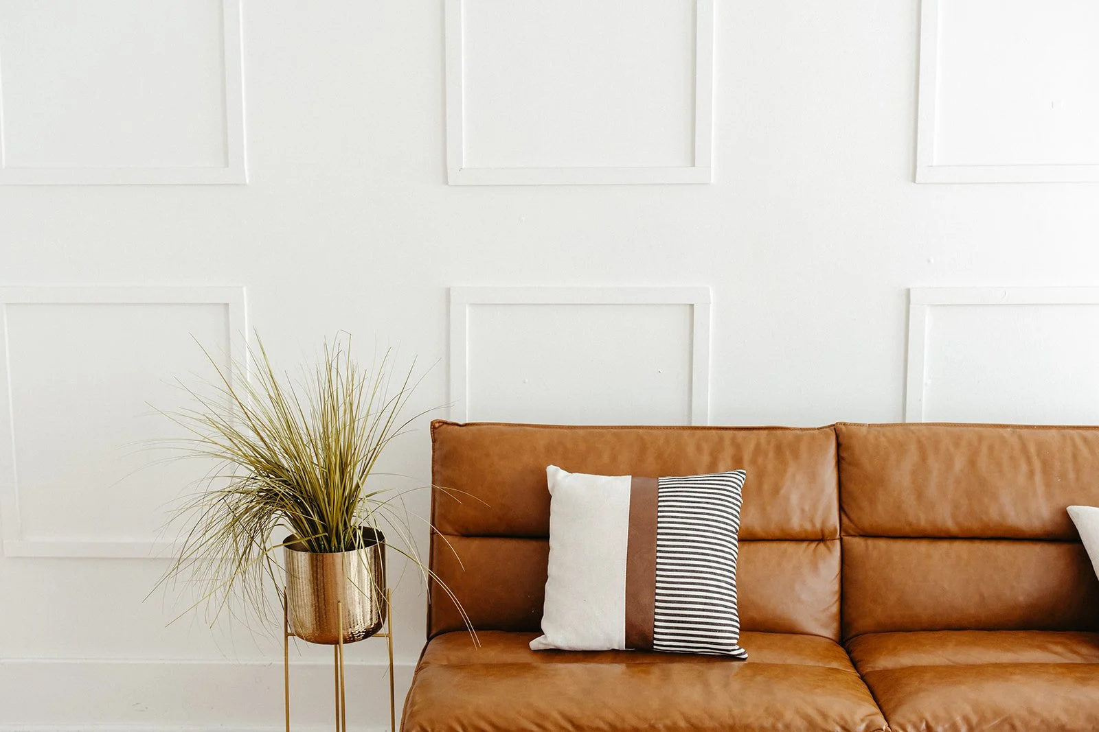 Brown leather couch and green plant in a Brea, CA anxiety and burnout therapy office.