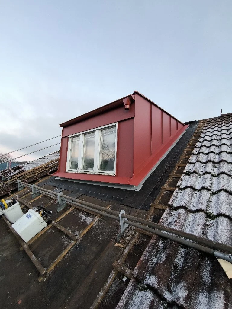 Taksättning med ett förbättrat takfönster på ett tak varmt under renovering.