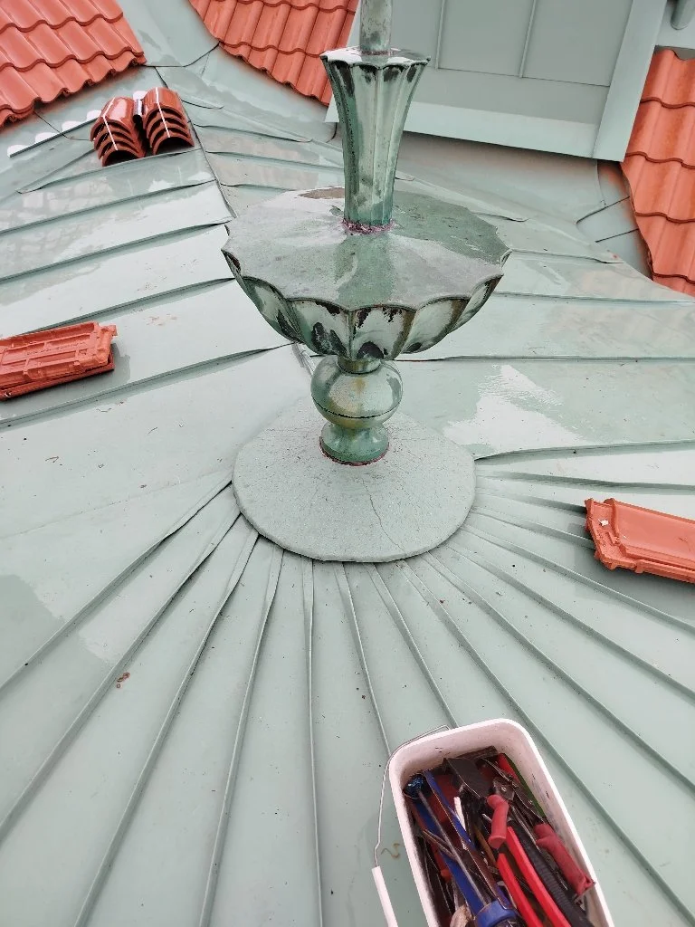 En metallkandelabervas på ett tak.