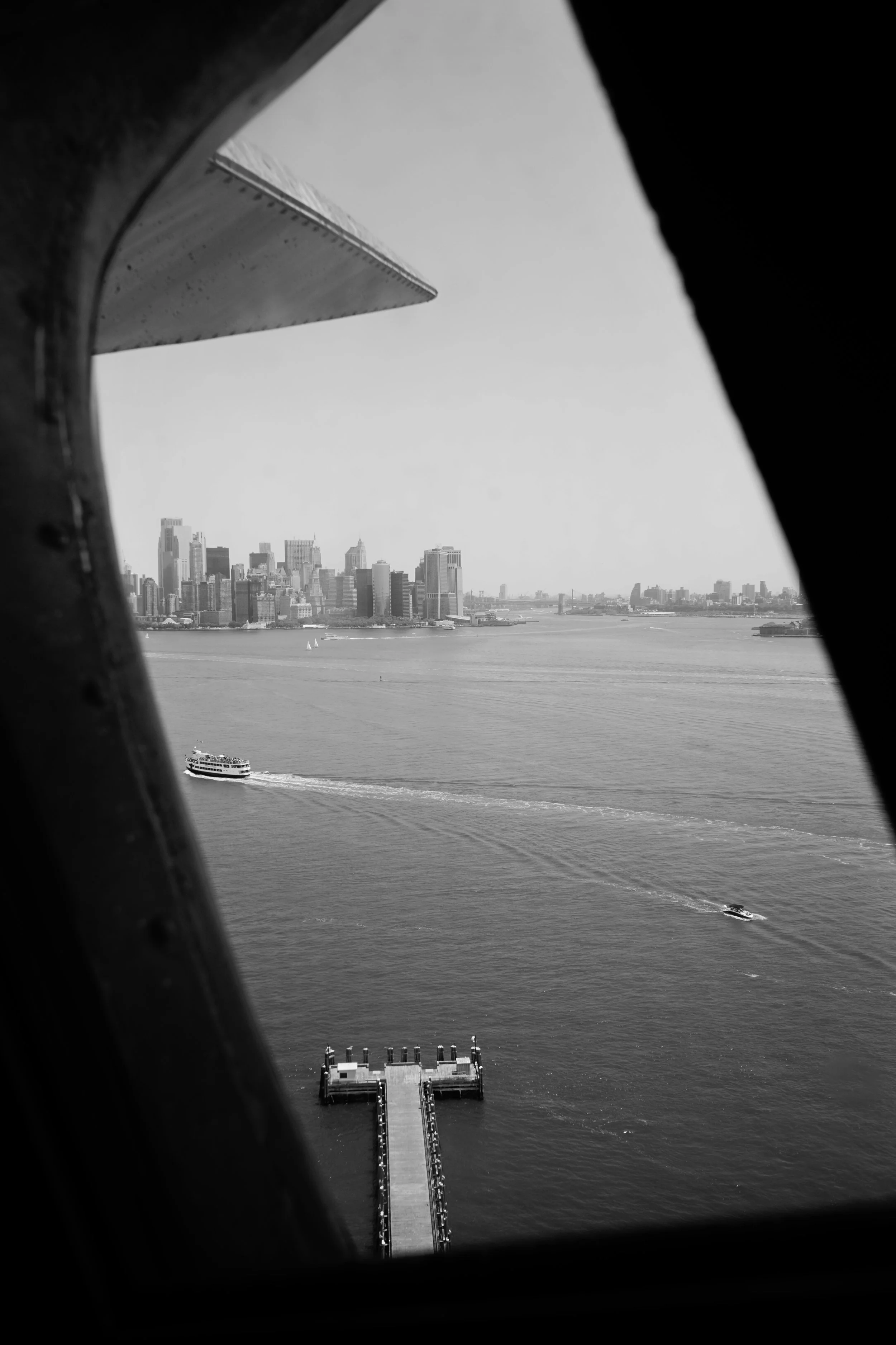 View of Manhattan skyline from a boat window in black and white.