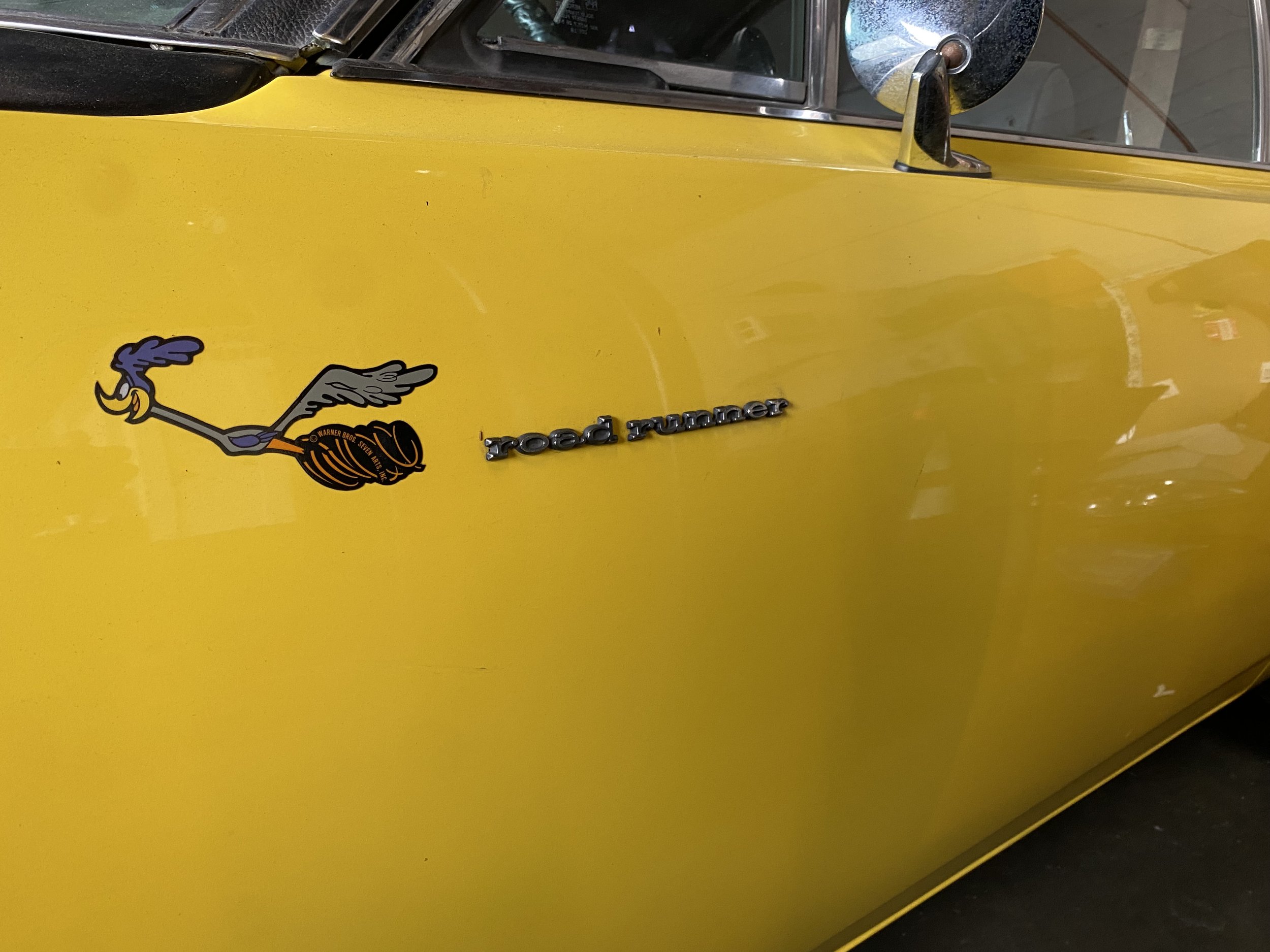 Close-up of the side of a yellow Jeep Road Runner with a cartoon Road Runner character decal.
