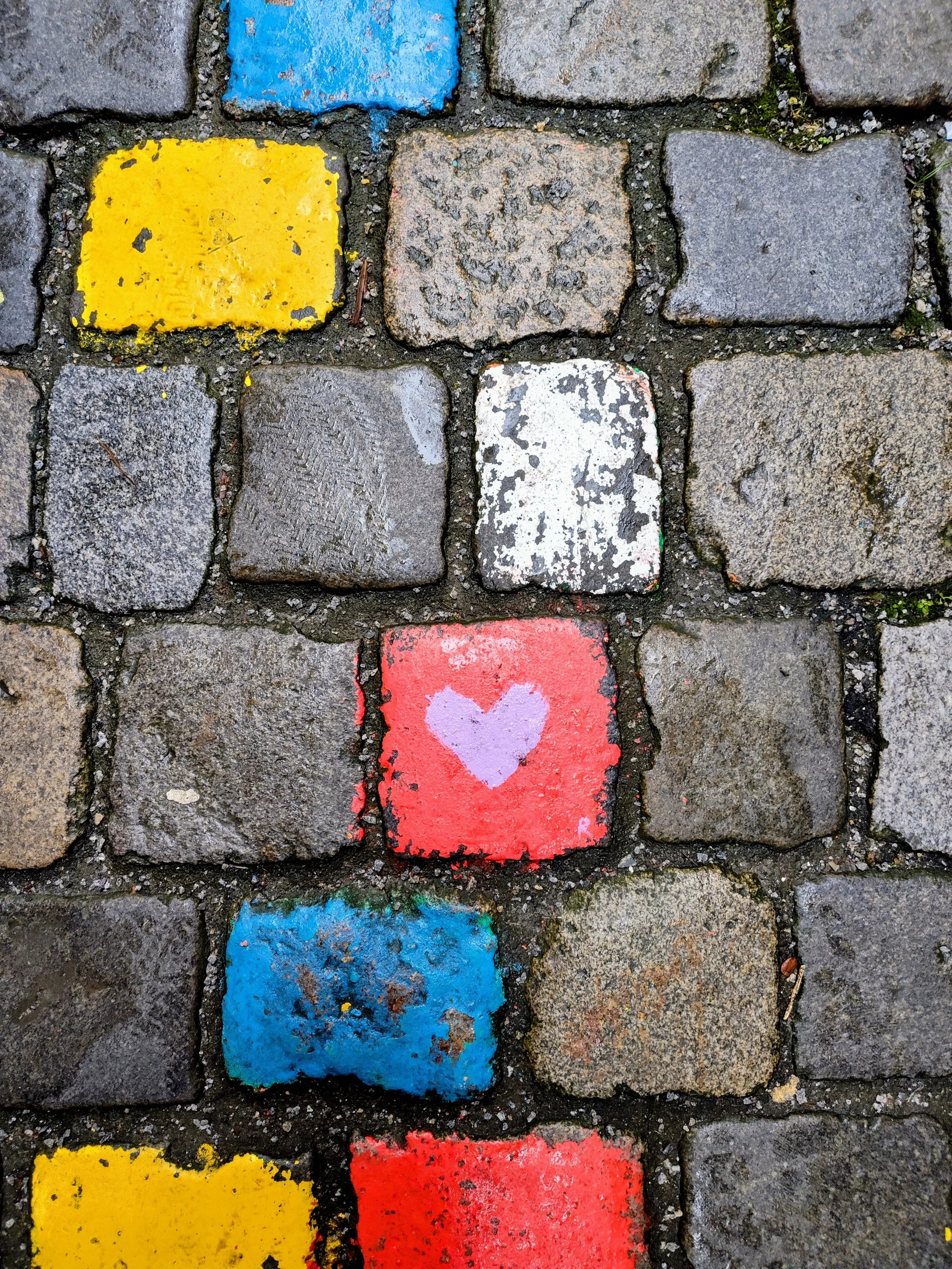 A heart painted onto the historic cobblestones of Passau, Germany, a local artistic tradition captured by the Sunrise Travel team during a European river cruise