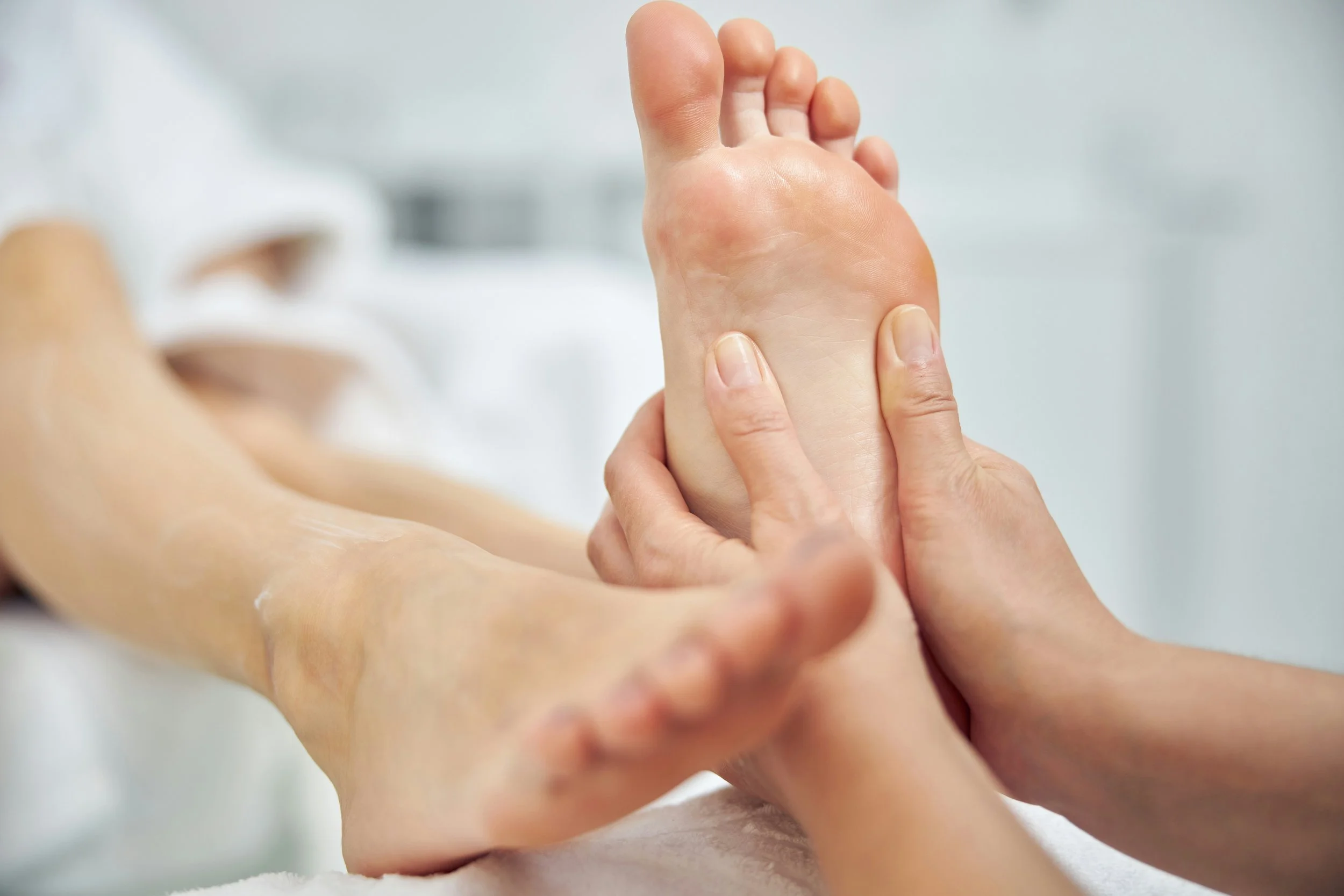 A person receiving a foot massage from a therapist.