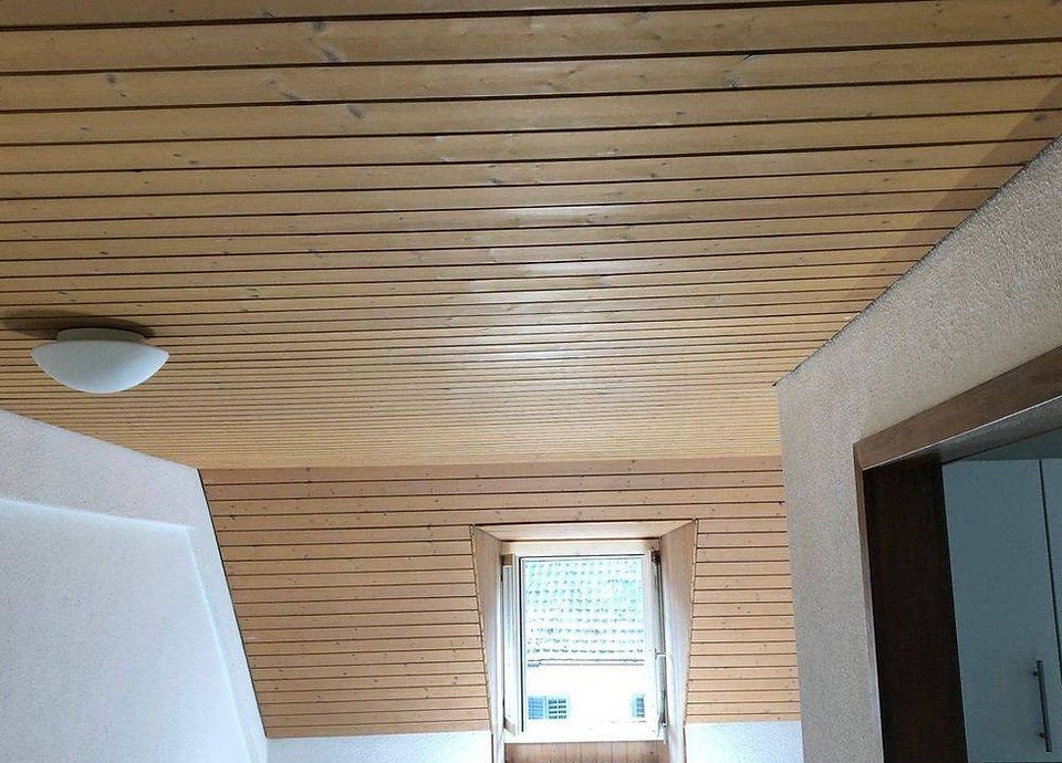 Decke aus Holzpaneelen mit einer kleinen Dachfenster