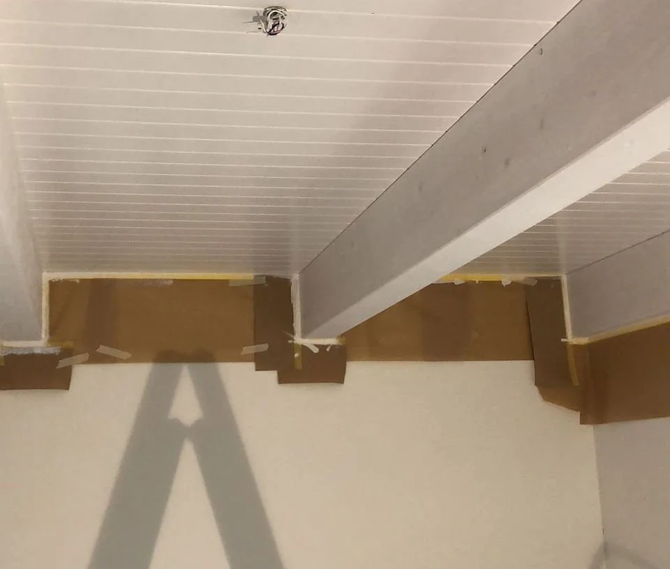 Innenraum einer Bauinstallation mit Decke, sichtbarem Träger, Wand und Baugerüst, ungeordnete Baustelle