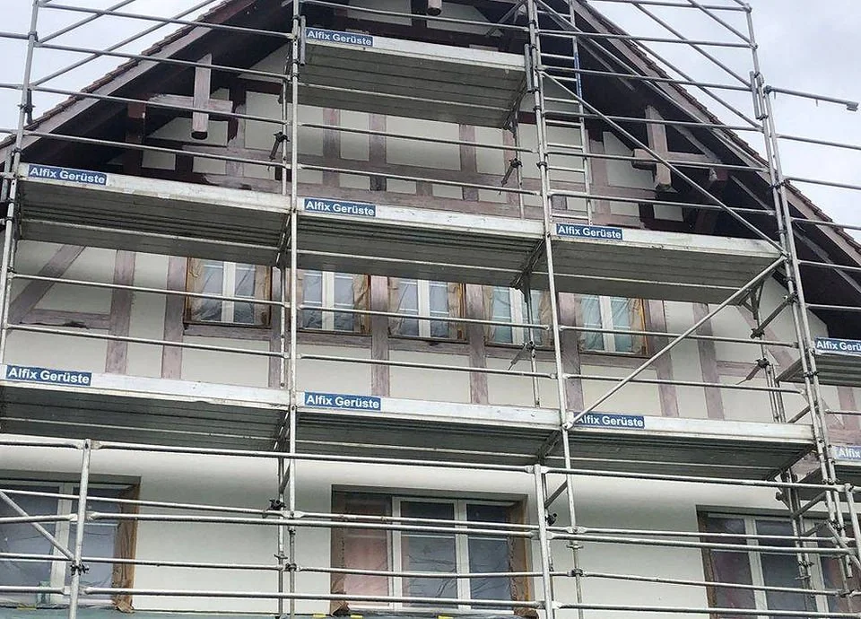 Mehrstöckiges Gebäude, das mit Gerüsten umgeben ist, während Renovierungsarbeiten durchgeführt werden.