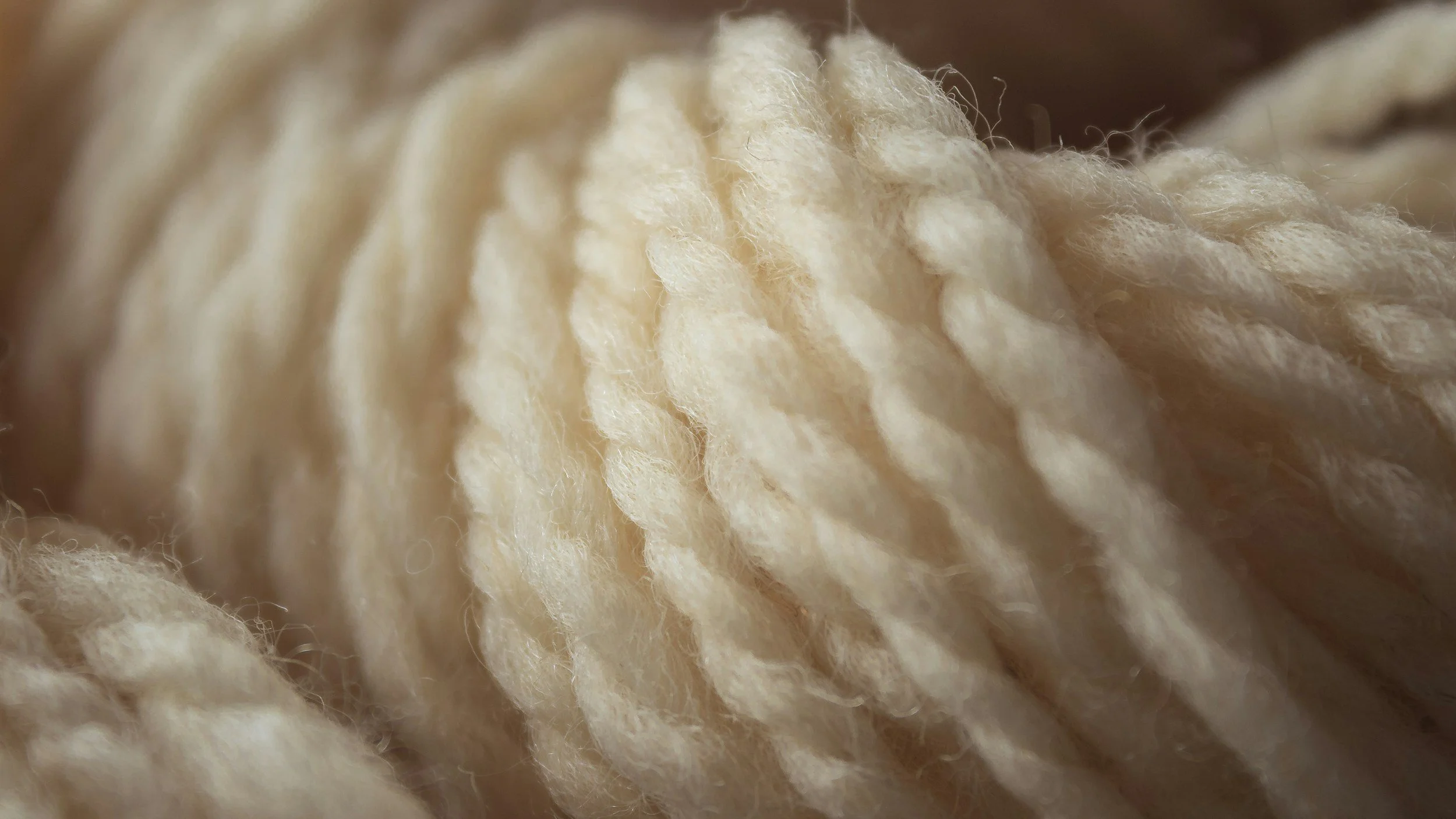 Close-up of cream-colored yarn strands.
