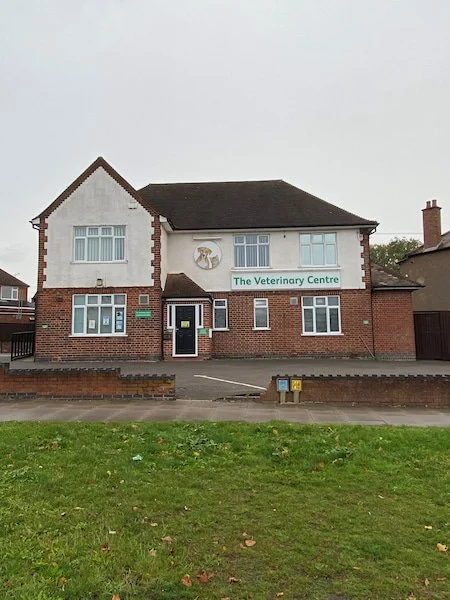 An old image of 'The Veterinary Centre' in Coventry with a veterinary logo, brick and white exterior, multiple windows, and a front sidewalk.