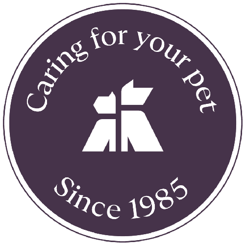 A circular logo with a dark purple background and white text that says 'Caring for your pet Since 1985' around a stylized white dog and cat silhouette in the center.