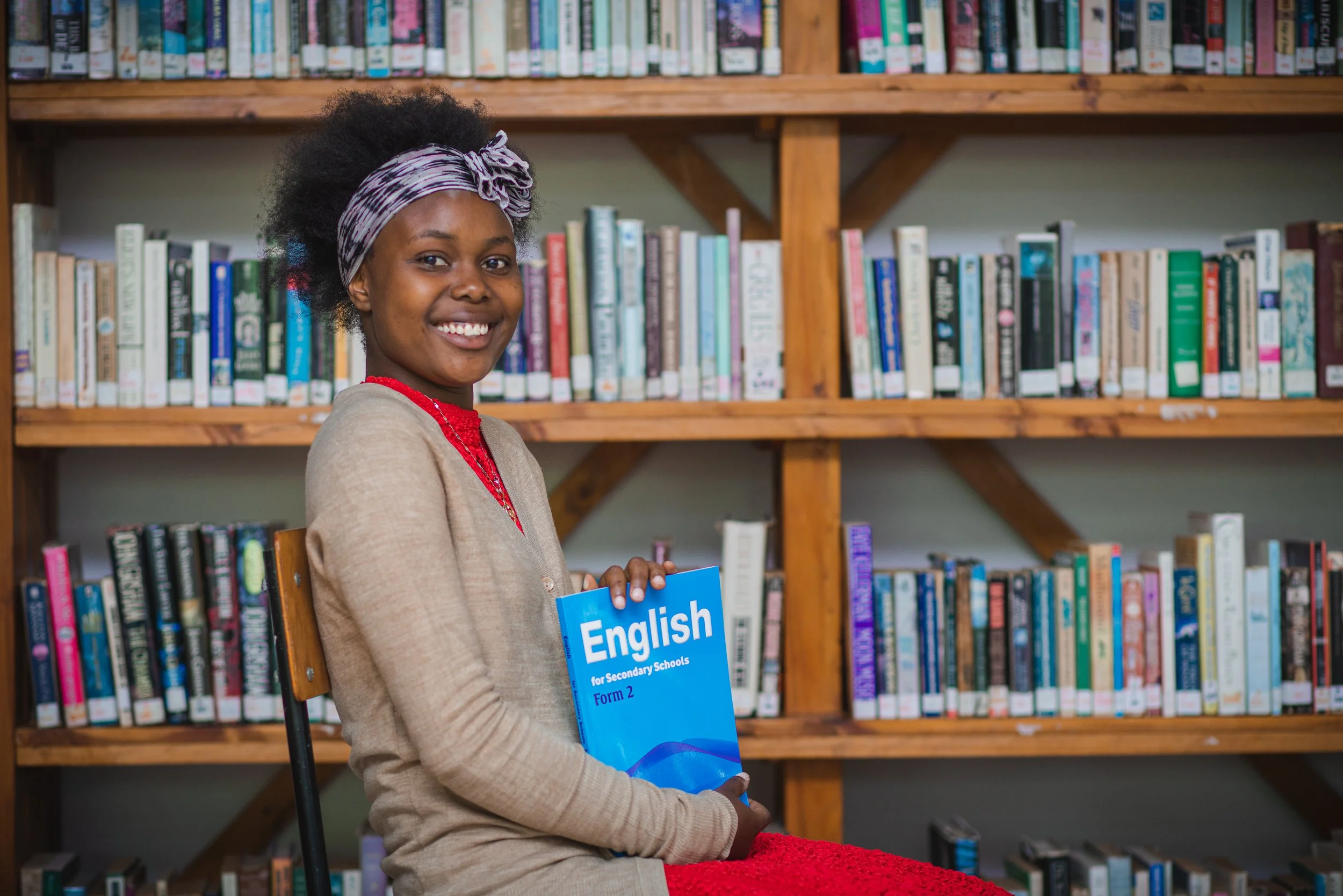 Image of a young girl holding a book about learning English.