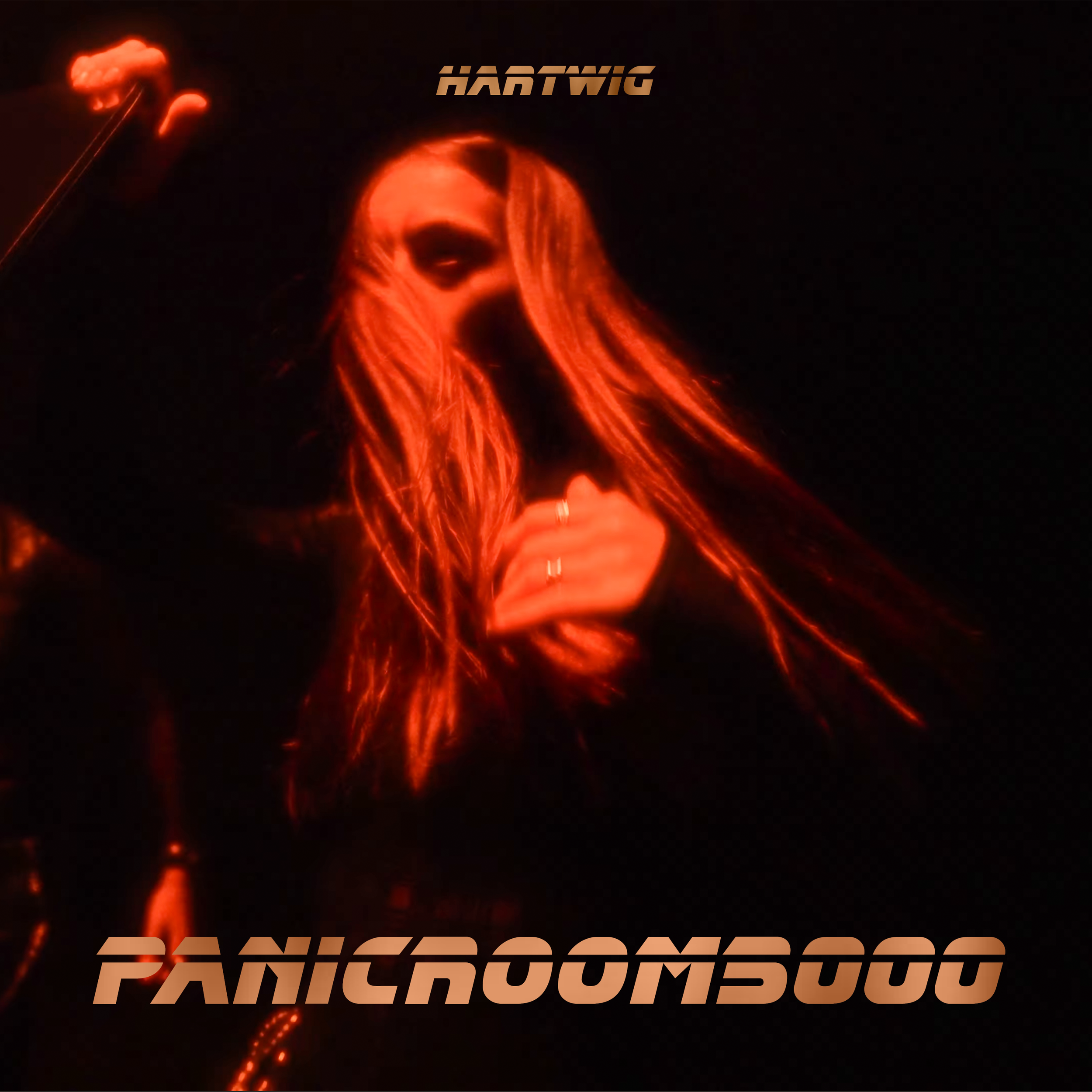 Image sombre avec une femme aux cheveux longs et roux, portant une tenue noire, et texte en haut 'HARTWIG' et en bas 'PANIC ROOM 500' en style futuriste.