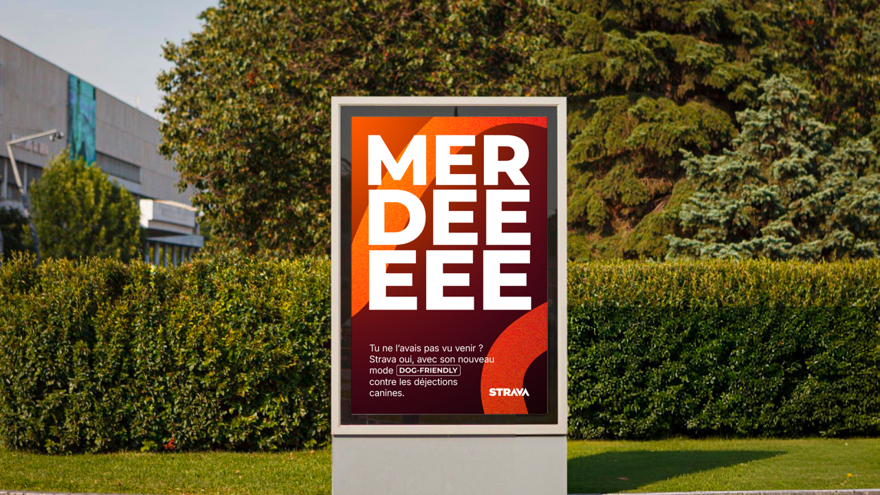 Panneau publicitaire pour l'application Strava, mettant en avant un mode pour chiens contre les déjections canines, avec un fond urbain et des arbres en arrière-plan.