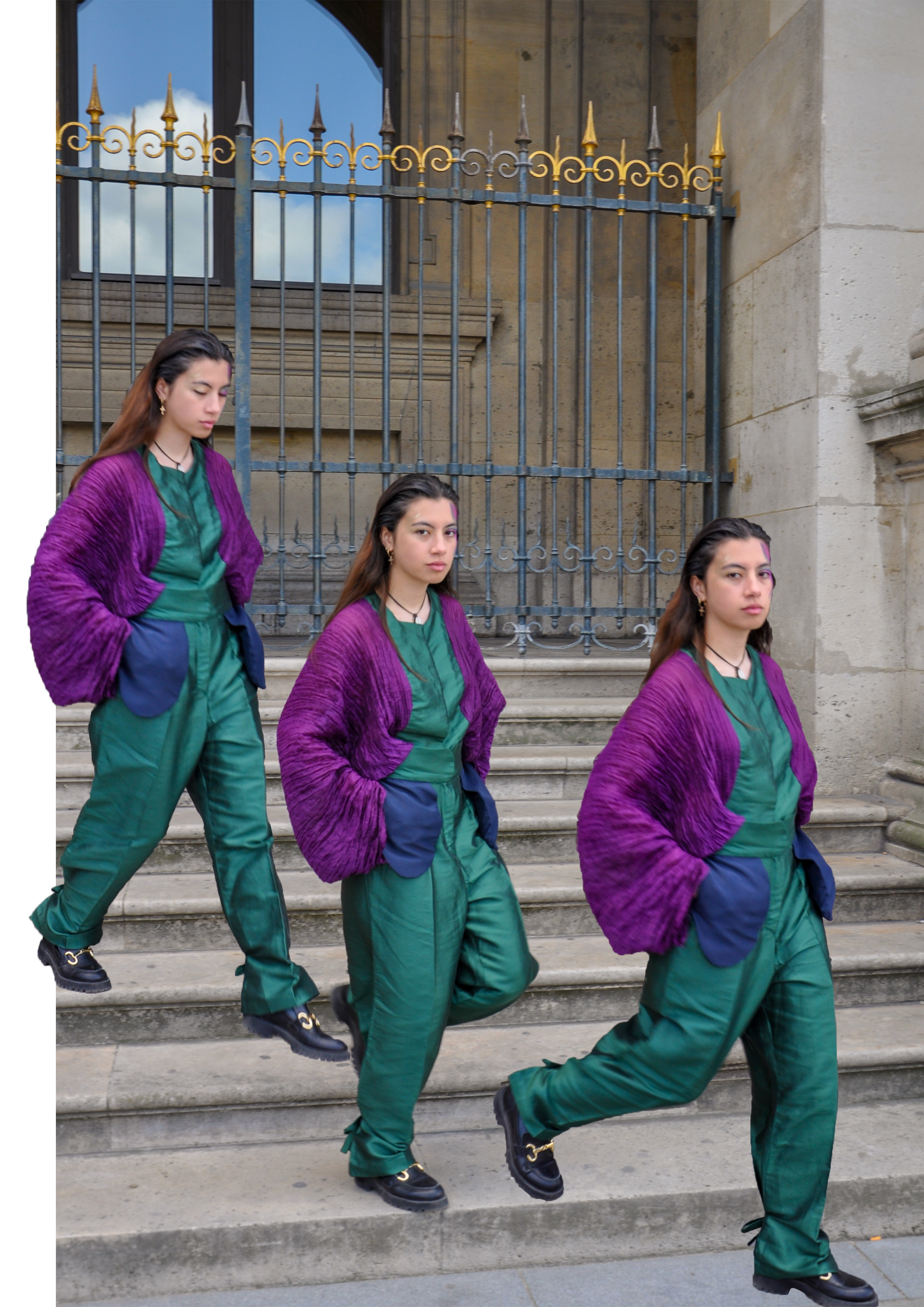 Une femme en multiple exemplaires descend des marches devant une grille en fer forgé d'une couleur or, portes en pierre et un mur en pierre. Elle porte un pantalon vert avec une veste violette.