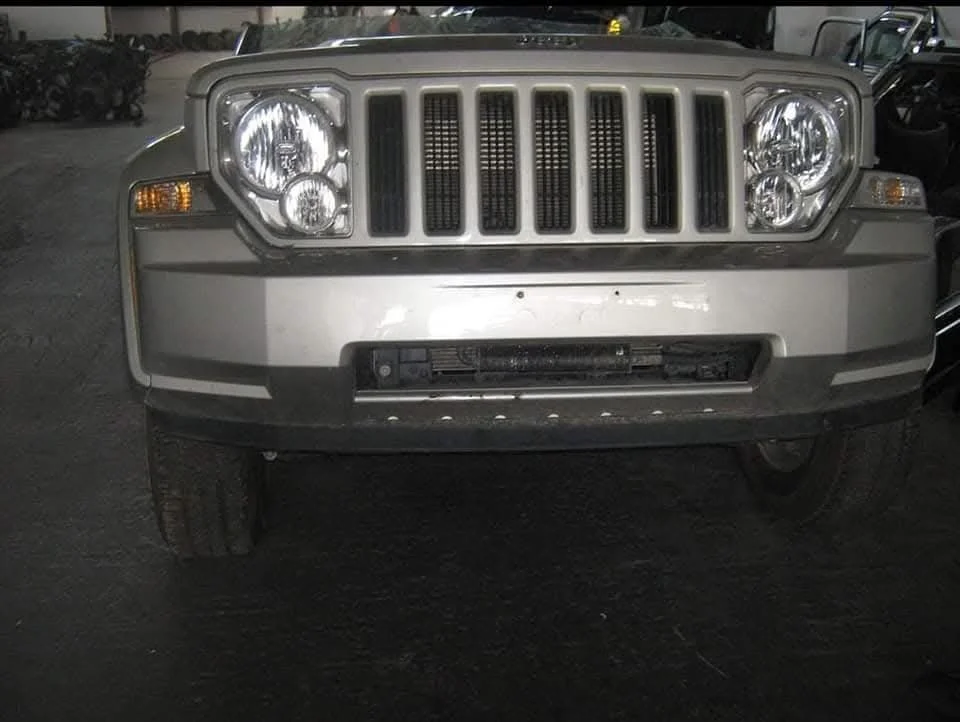 Front view of a silver Jeep SUV showing its grille, headlights, and bumper.