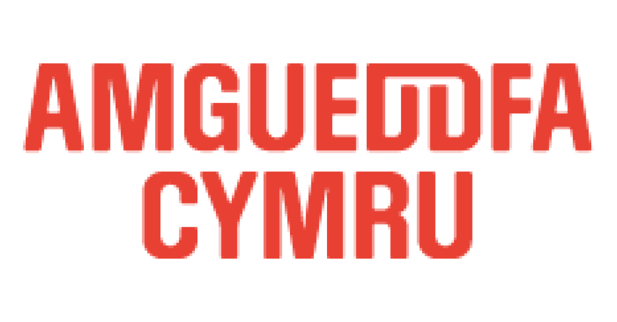 Red pixelated text that reads "AMGUEDDA CYMRU" on a black background.