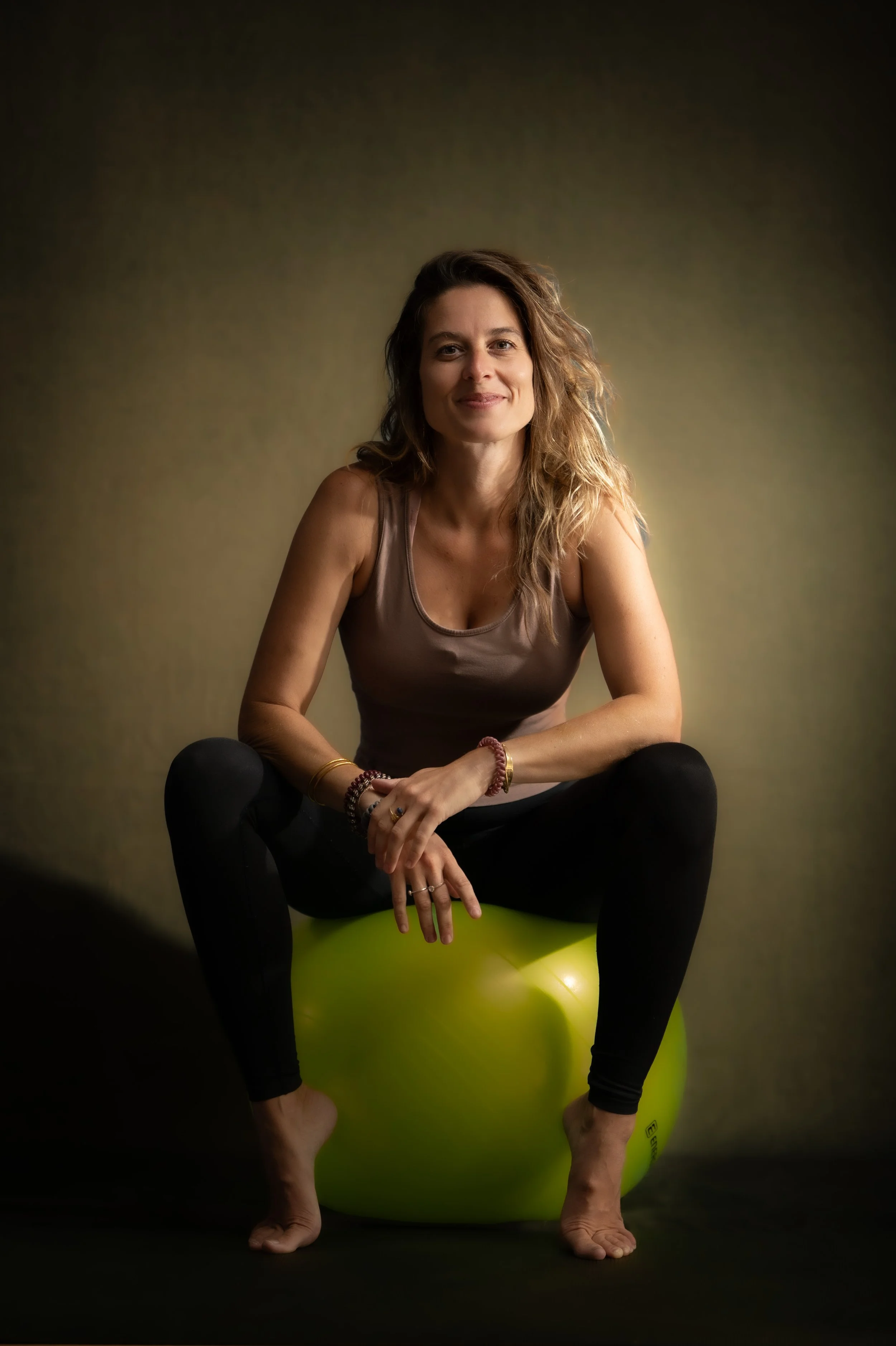 Jeune femme coach sportive en portrait studio, dynamique et souriante