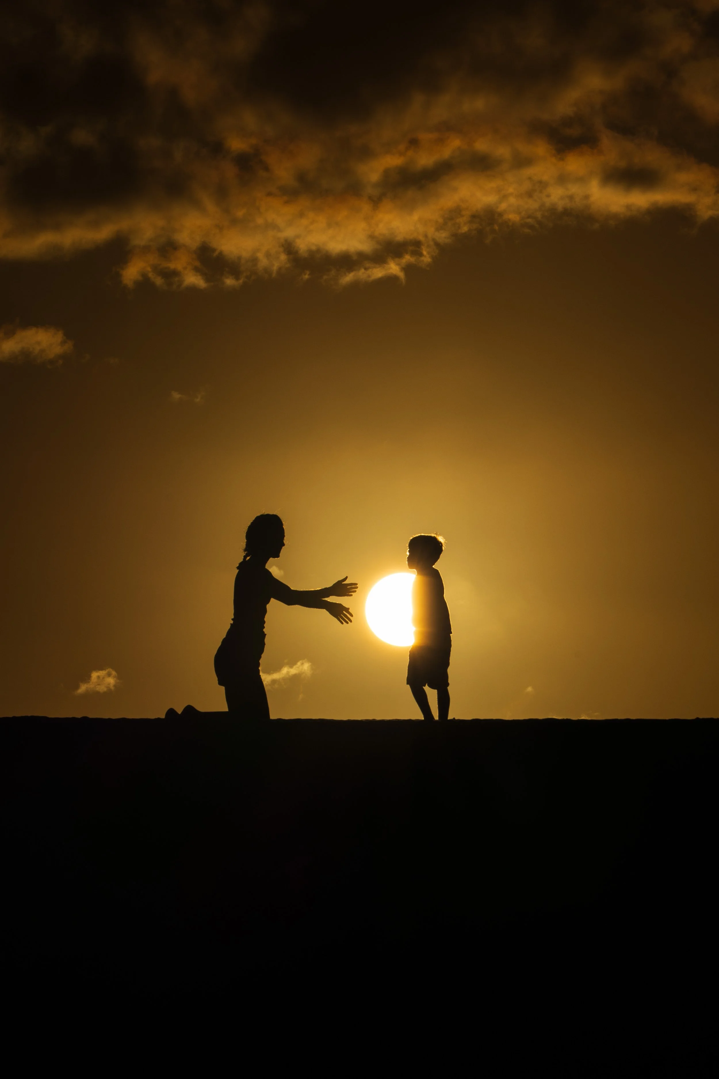 Mère et enfant en ombre chinoise au soleil couchant
