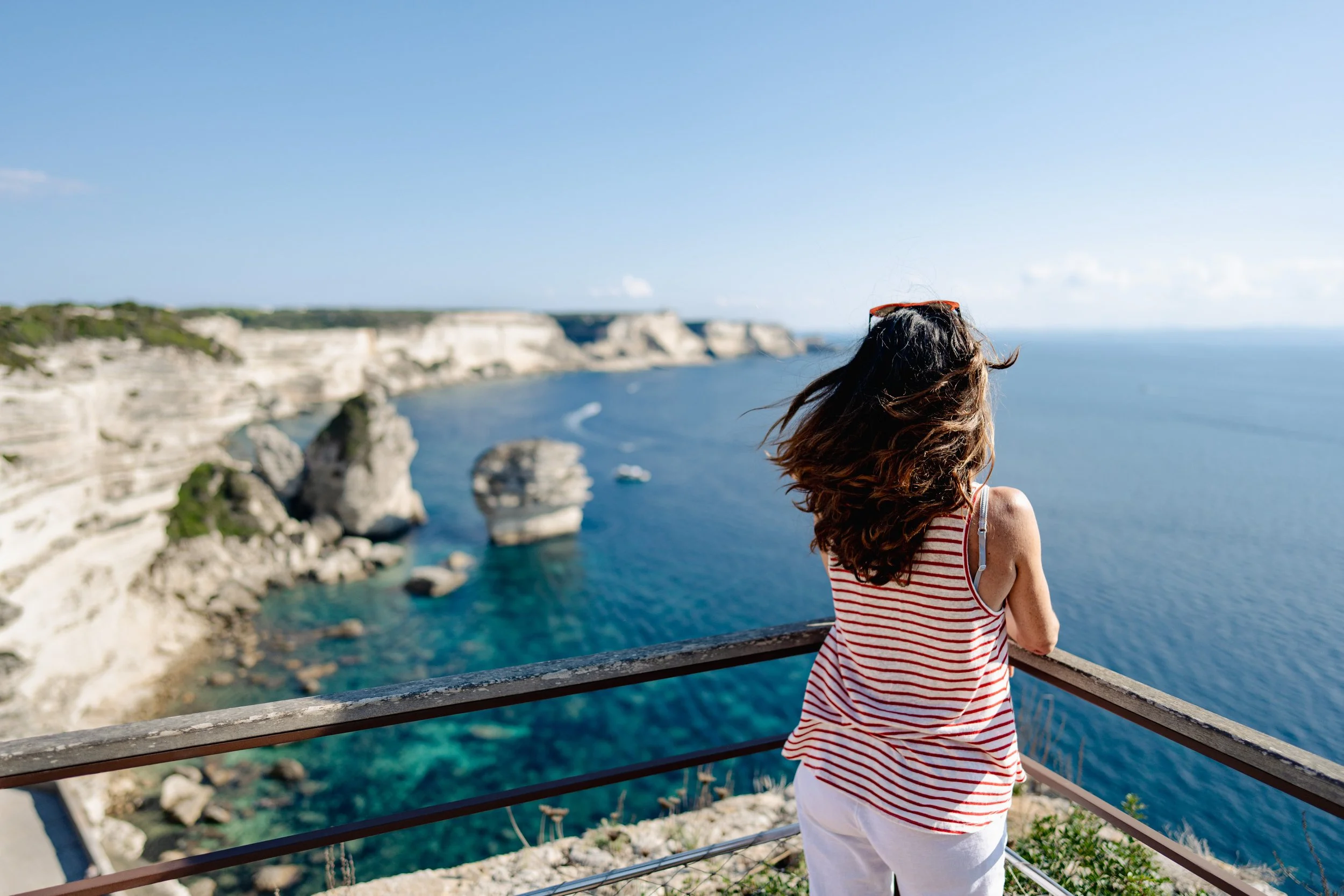 Femme avec vue plongeante sur les falaises de Bonnifacio