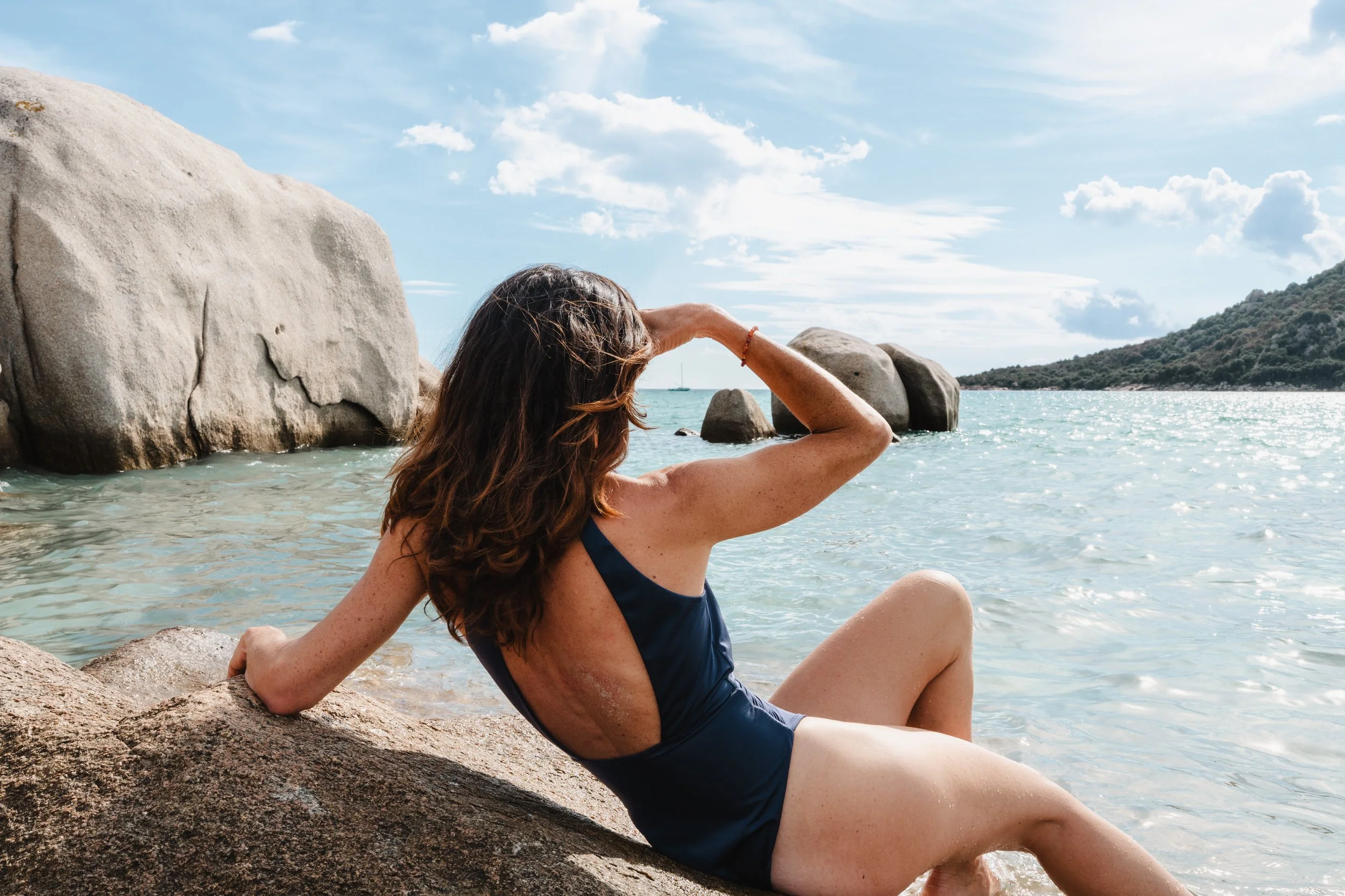 Femme en maillot de bain regardant l’horizon sur la mer