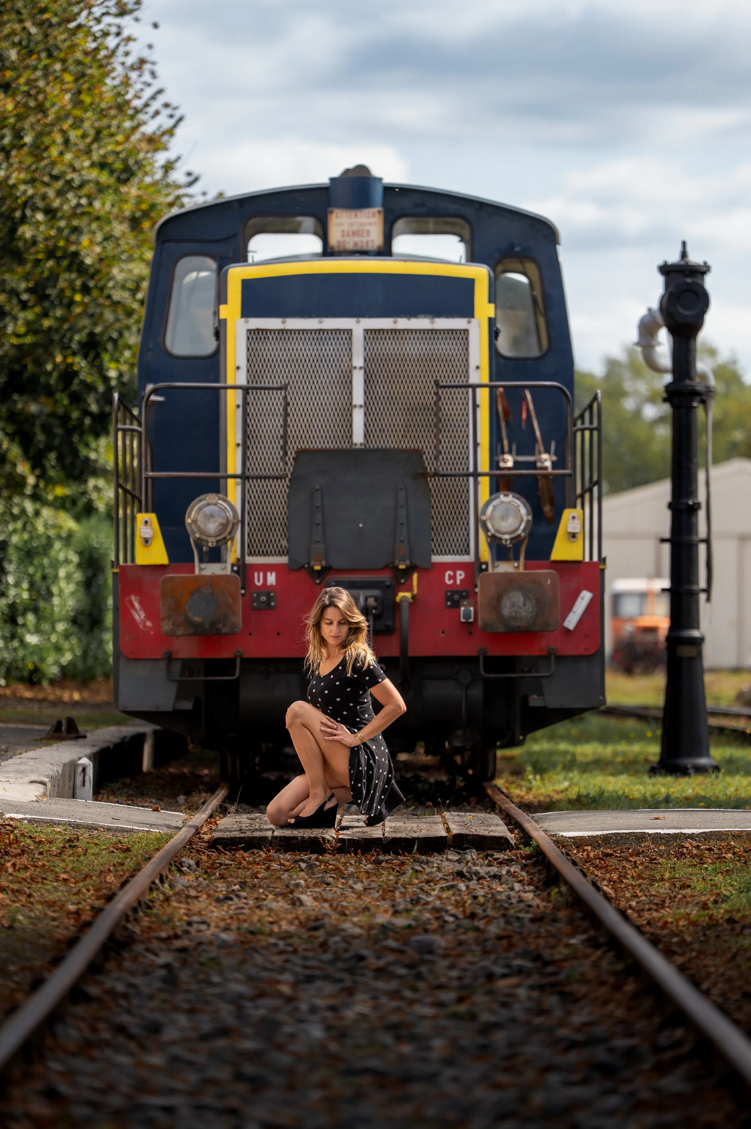 Jeune femme sexy devant une locomotive ancienne
