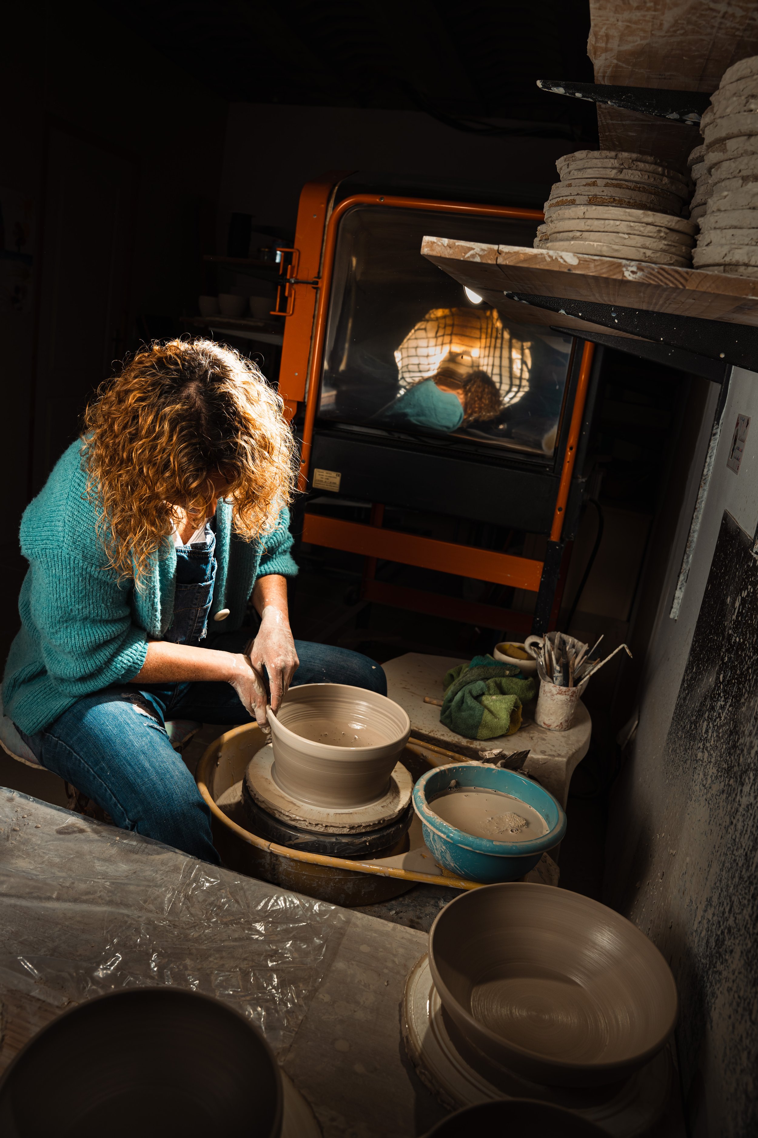 Artisan céramiste dans son atelier, finition d’un saladier, beauté et précision du geste