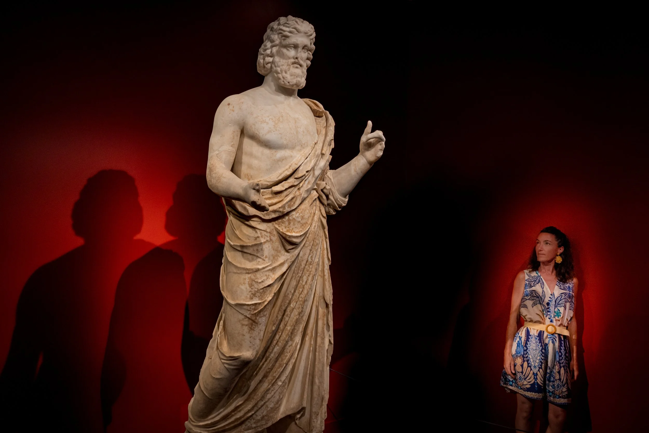 Femme et statue romaine dans un jeu de lumière rouge