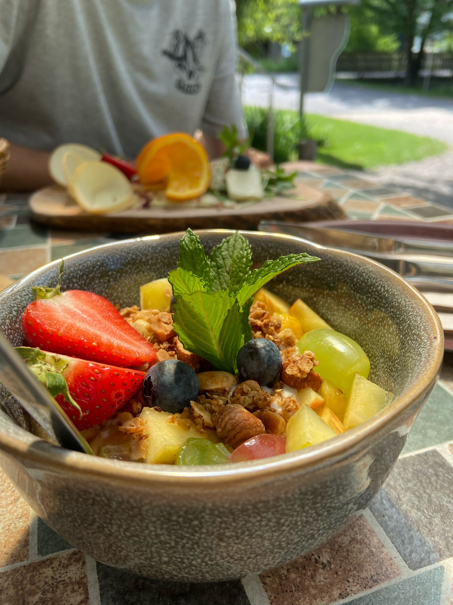 Frischer Obstsalat mit Mango, Erdbeere, blaue Traube, Minzblatt in einer Schüssel