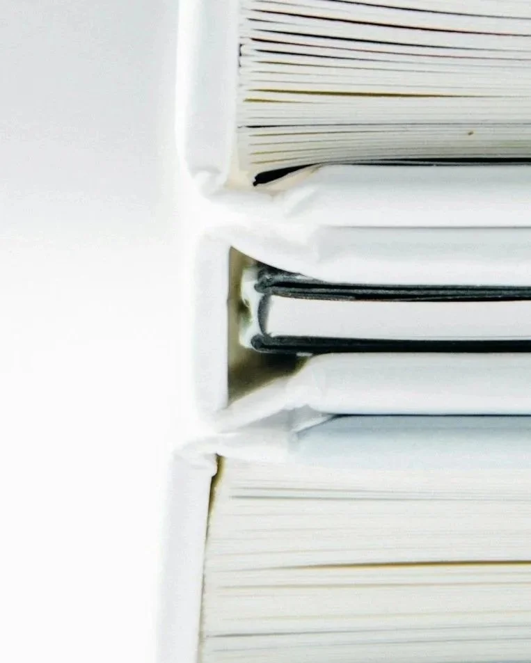 Close-up of stacked paper documents or files in white folders.
