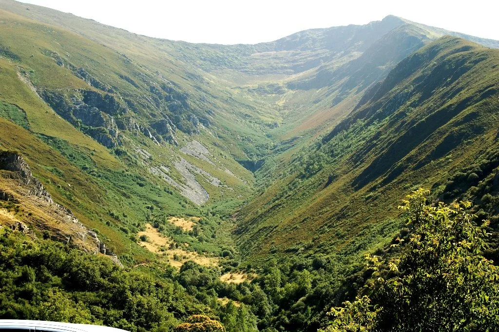 Vista de un valle rodeado de montañas verdes.