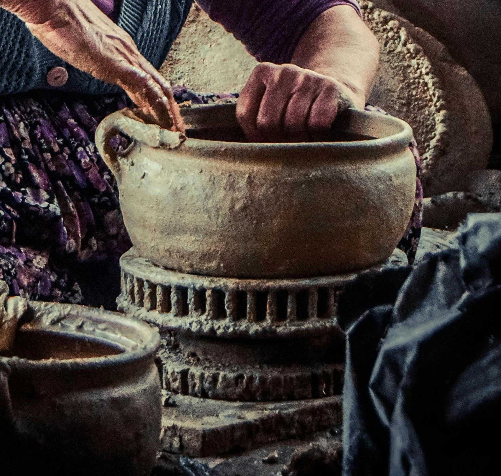 Woman's hands crafting a traditional pottery vessel