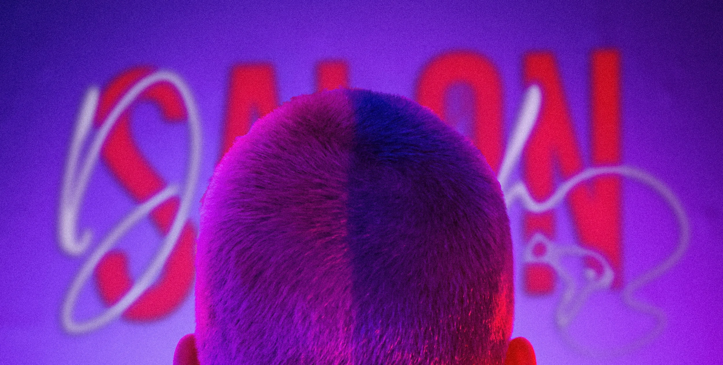 Persoon met een buzzcut kapsel voor een neonbord waarop een logo van Salon Deborah staat in rode en witte letters.