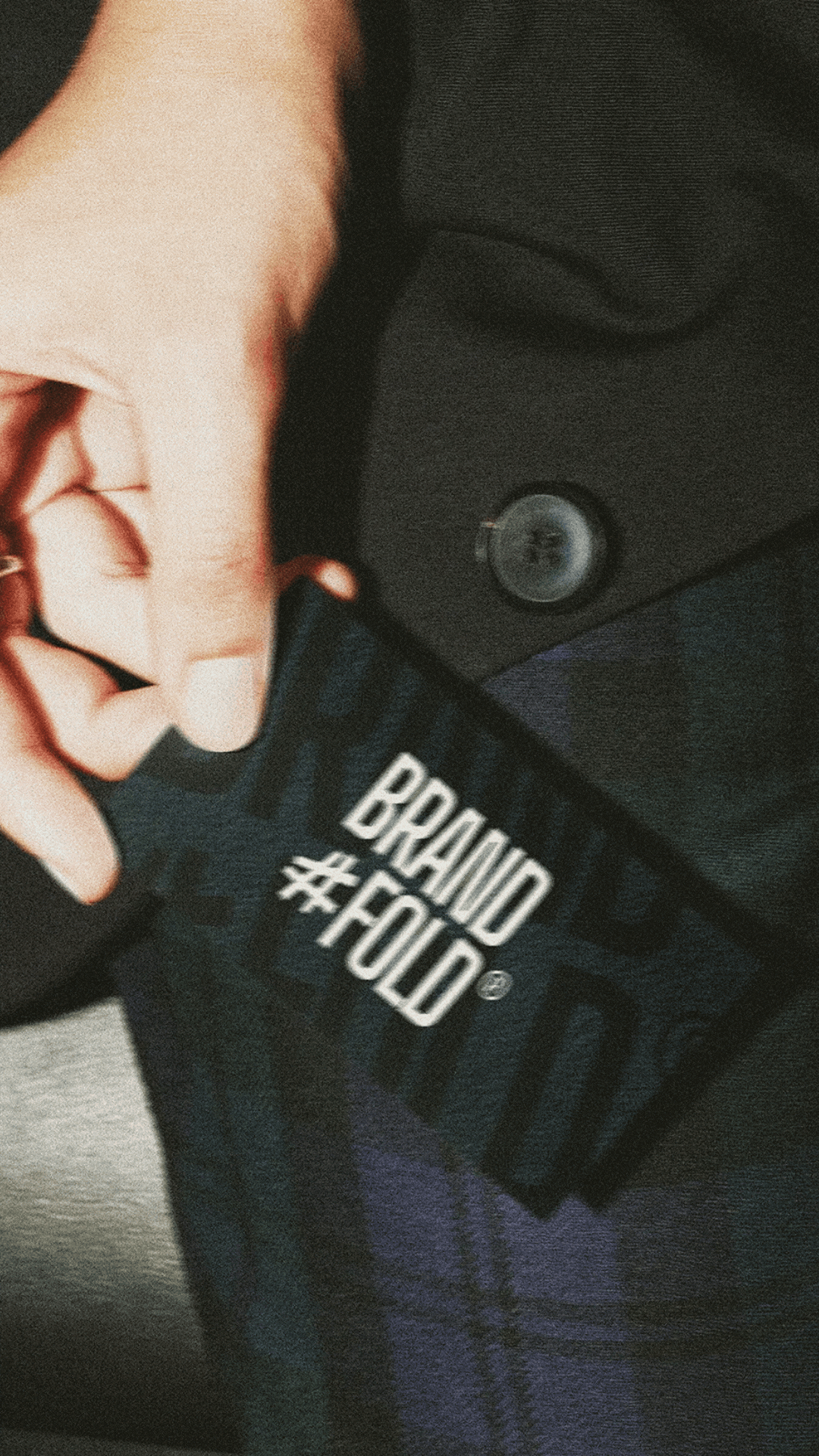 Hand die een Brandfold® visitekaartje vasthoudt, professioneel grafisch ontwerp en branding studio