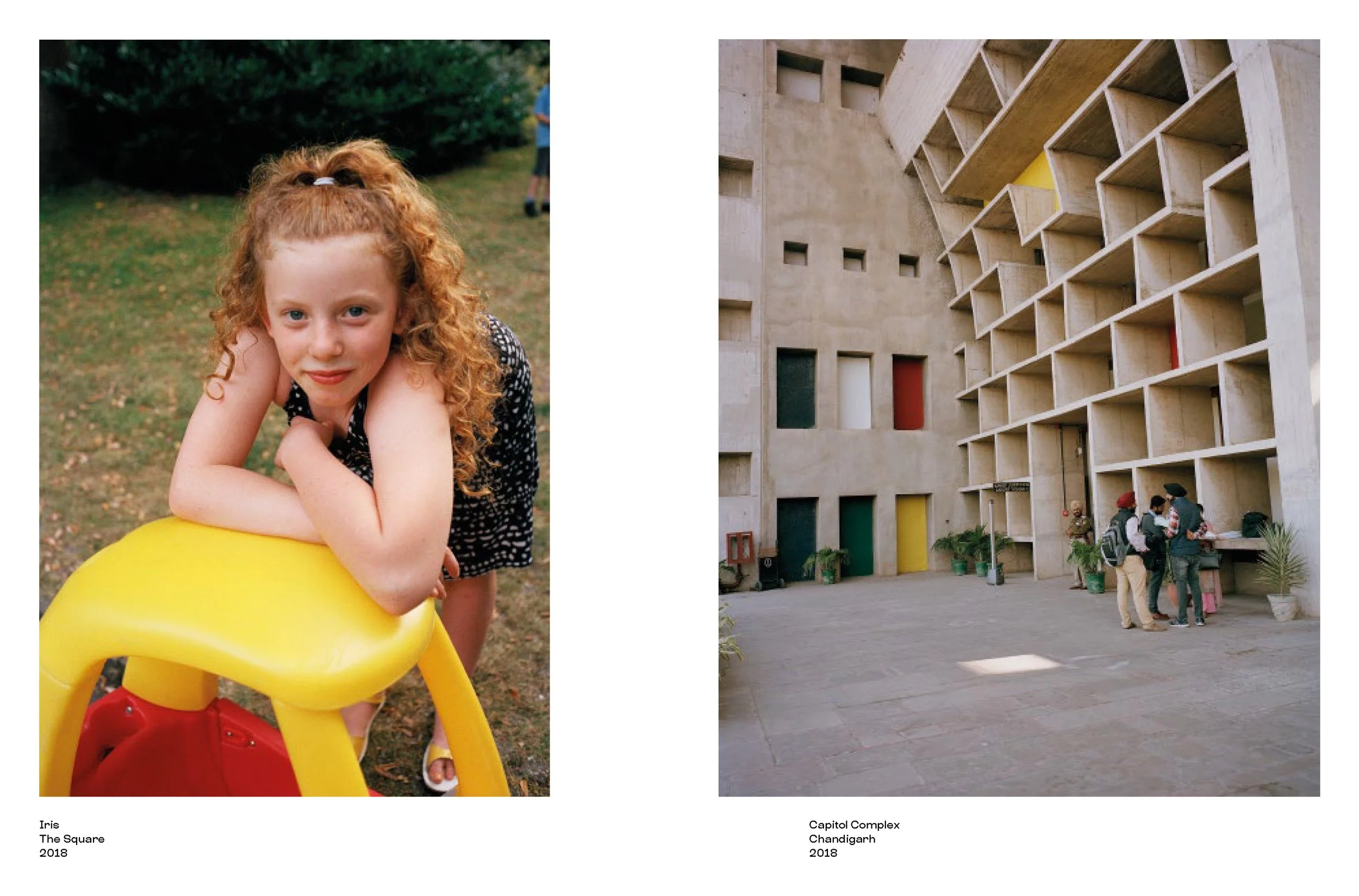 A young girl with red curly hair leaning on a yellow playground structure outdoors, and a modern concrete building with colorful square windows and a small group of people gathered in a courtyard.