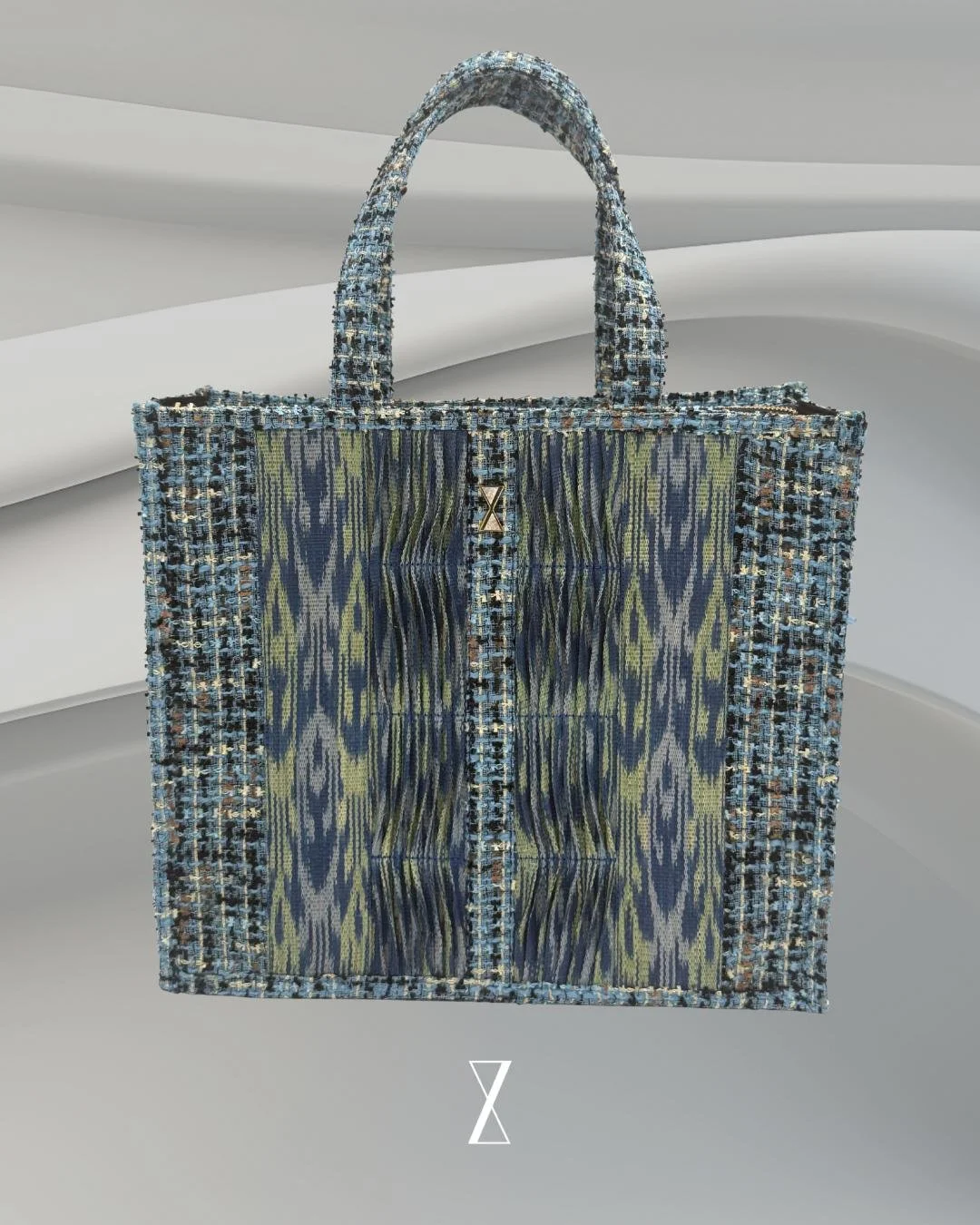 A handbag with a multicolored woven pattern, inches wide, set against a light gray, abstract background.