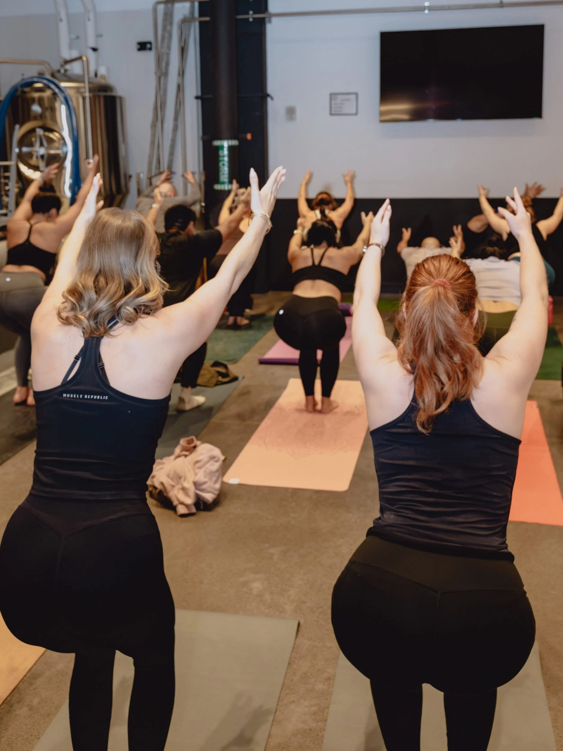A group of pop-up attendees practicing mindful movement at a pilates pop-up event.