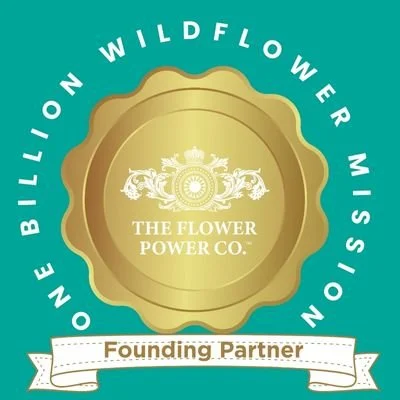 Gold seal with the text "The Flower Power Co." and a decorative crest in the center, set on a teal background with circular text "one billion wildflower mission" and a white ribbon banner reading "Founding Partner."