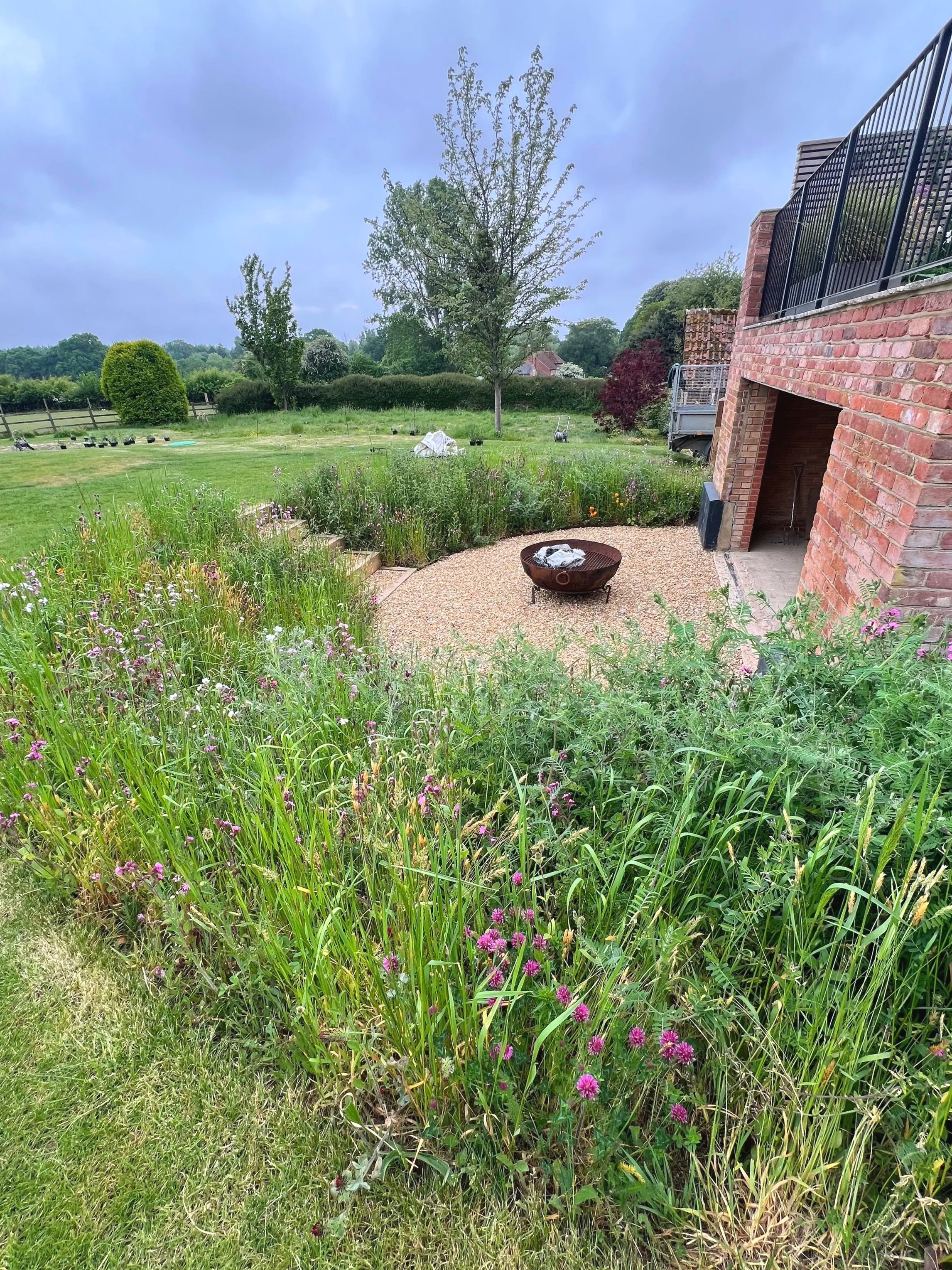 Wildflowers edge a gravel fire pit area