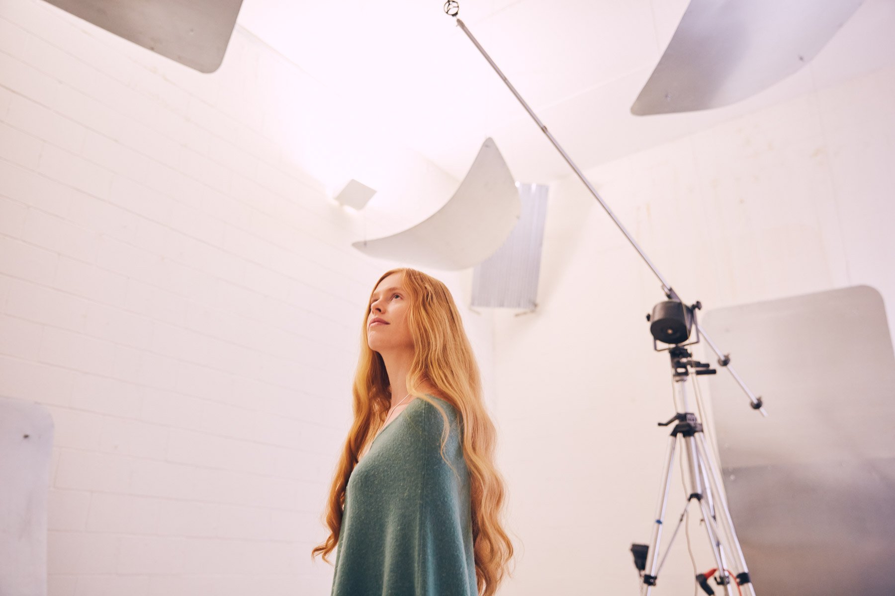 Emma Orfield with long hair in a auditory reflection room with white walls and large panels, Orfield Labs Minneapolis Minnesota