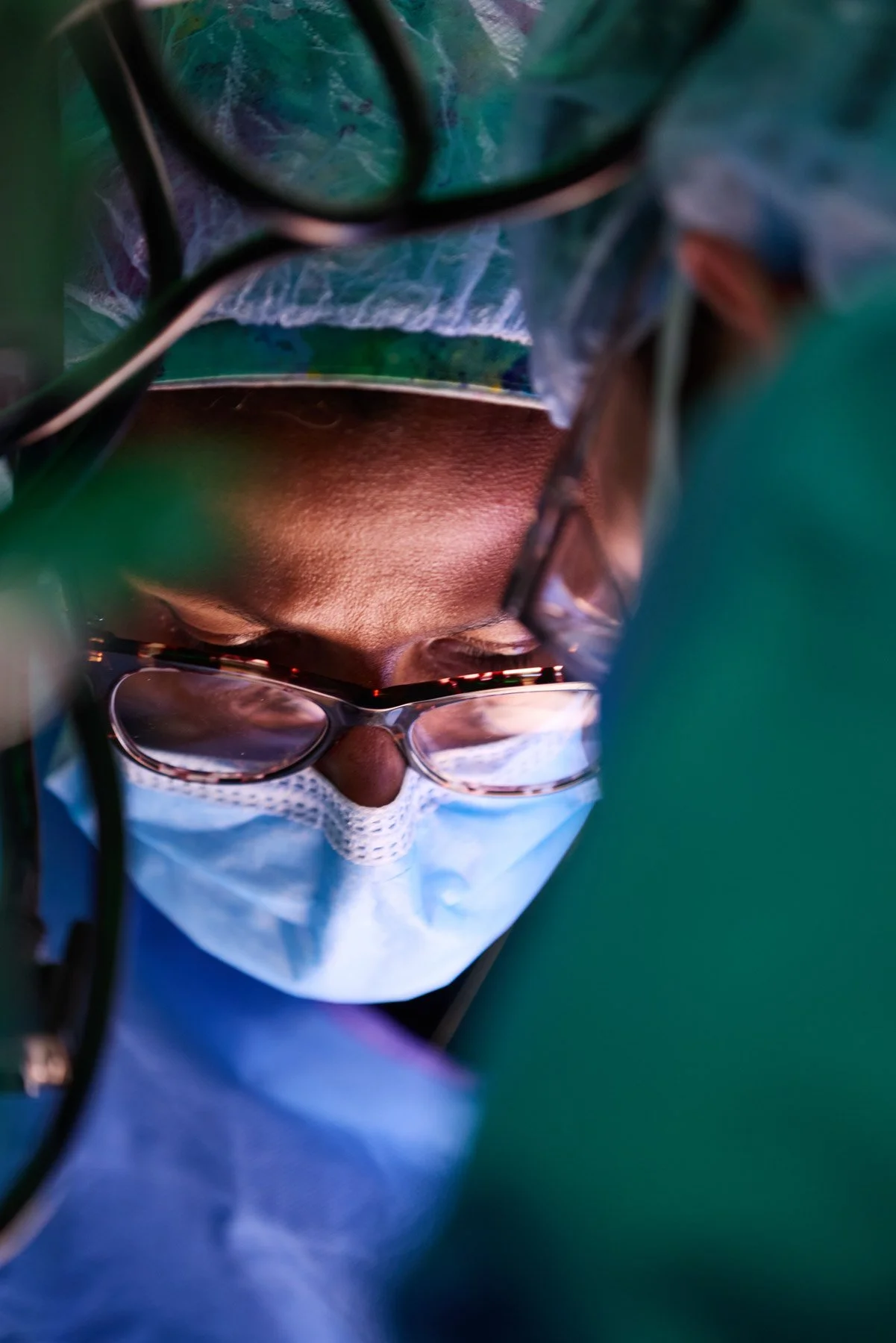 A close-up of female healthcare worker Dr Patricia Sylla wearing a face mask, glasses with reflection, and a surgical cap, shown from a closeup frontal angle. At Mount Sinai hospital in New York City