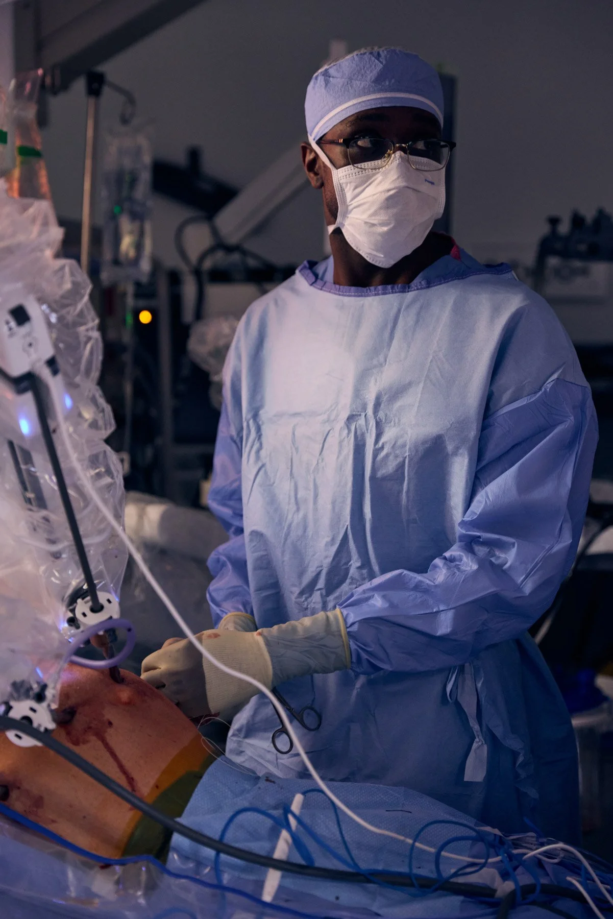 Nigerian surgeon Gbalekan Dawodu wearing protective gear performing surgery in an operating room. At Mount Sinai Hospital in New York City