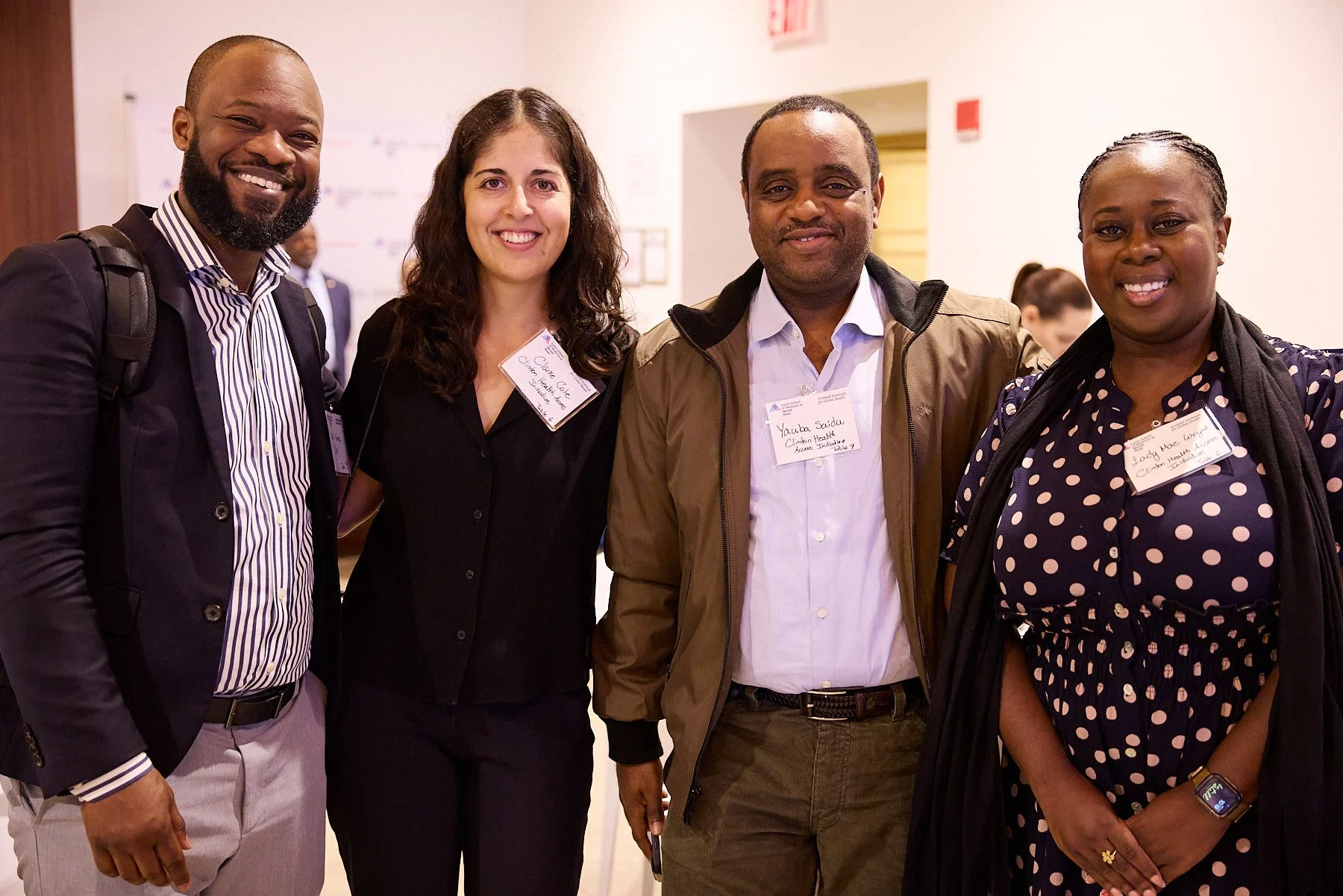Four people standing together at a professional event, smiling at the camera.