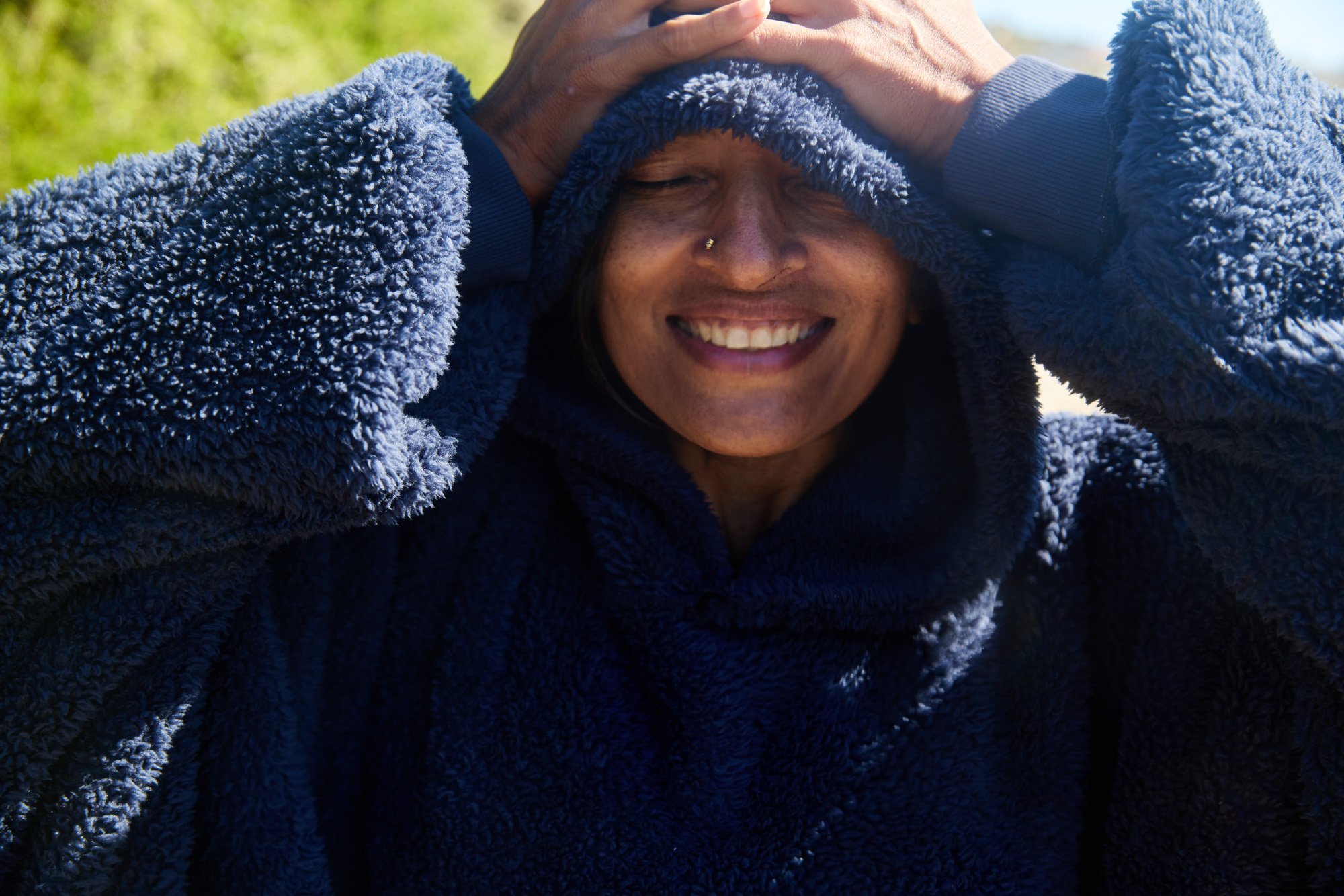 Smiling Swati Thiyagarajan in a thick, fluffy, blue hoodie after a swim near her home in Cape Town South Africa