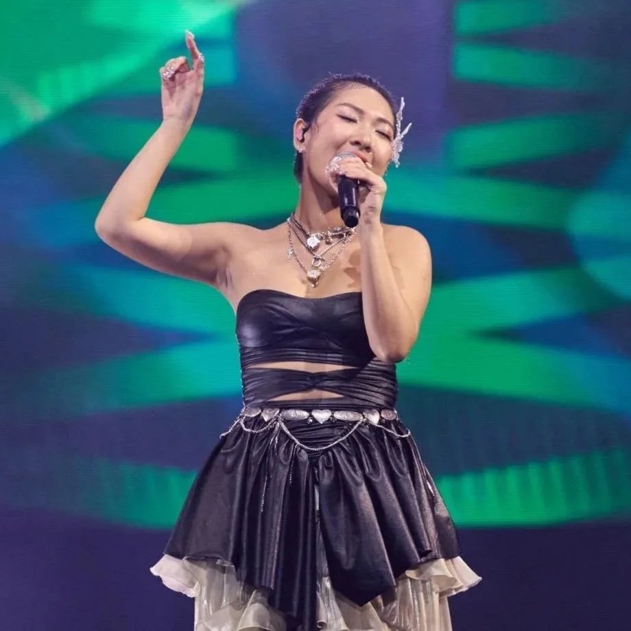 Singapore Artiste singing into a microphone on stage. Hair and Make up by Cheron Tan (Muacher).