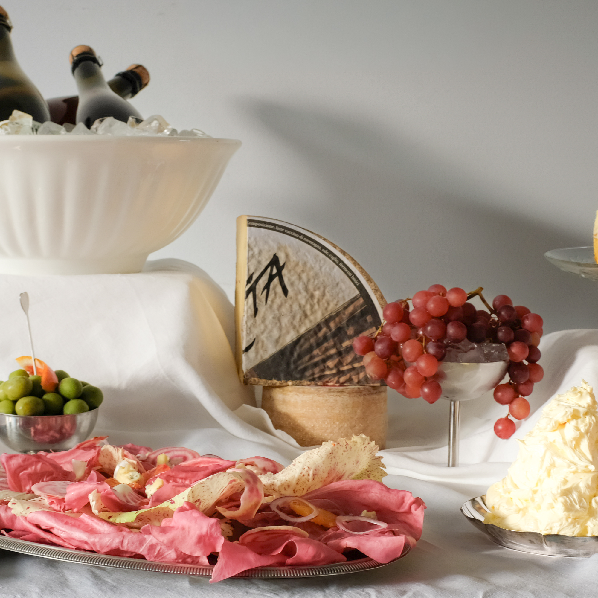 Assorted cheeses, grapes, and appetizers on a buffet table.
